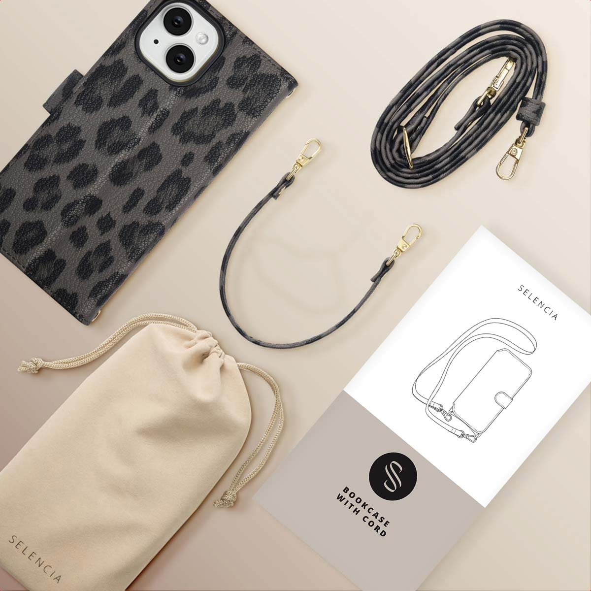 Een telefoonhoesje met luipaardprint, een zakje met trekkoord en een crossbodyriem worden weergegeven, samen met een boekje.
