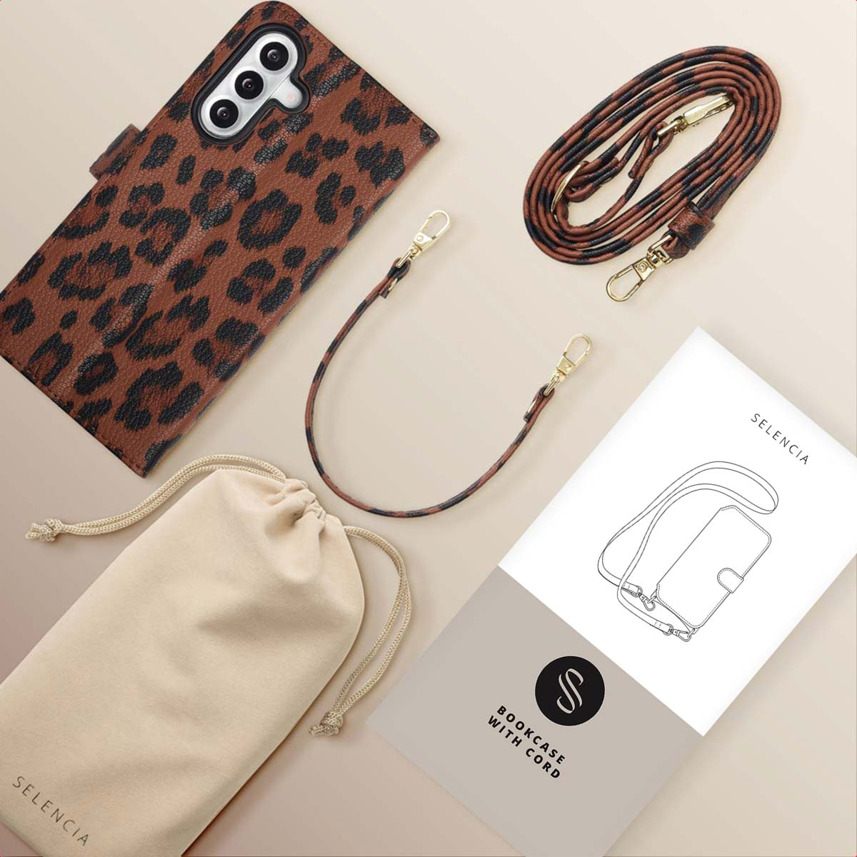 Étui de téléphone à imprimé léopard, sangle, pochette et livret sur surface beige. Accessoires pour un téléphone.