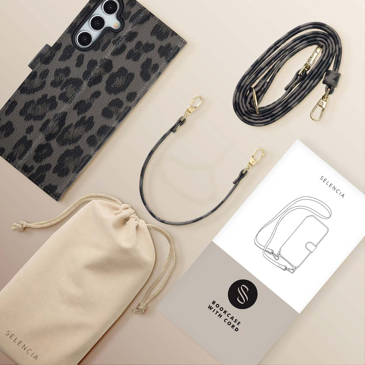 Un étui de téléphone à imprimé léopard, un téléphone, un cordon, une pochette beige et un livret sont posés sur une surface beige. La marque est Selencia.