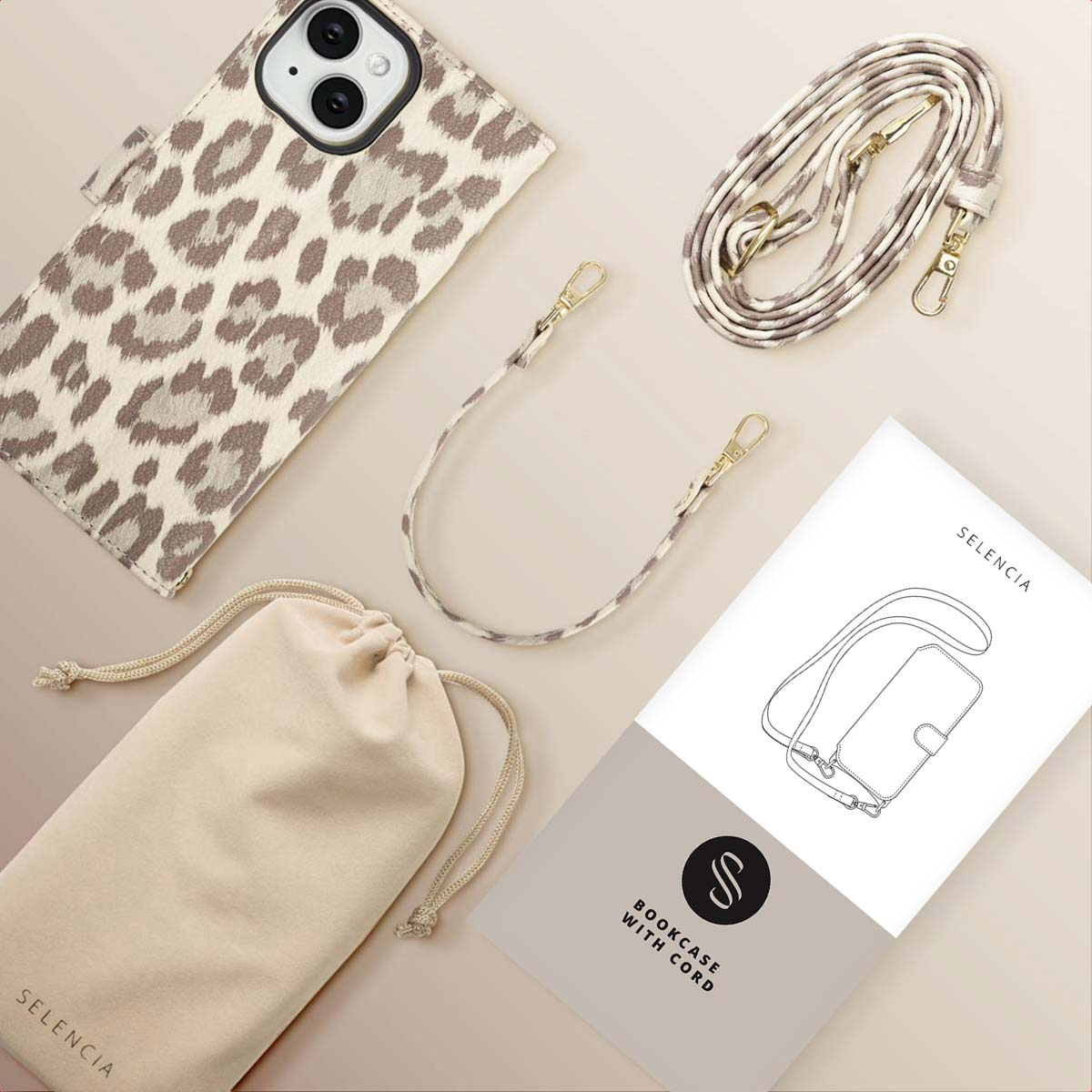 Een iPhone-hoesje met een luipaardprint, een bijpassende riem, een beige zakje en een handleiding, allemaal op een lichte achtergrond.