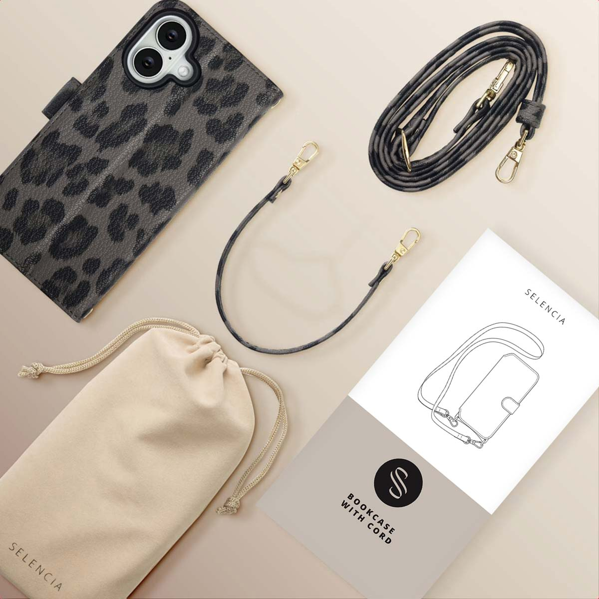 Una custodia per telefono con stampa leopardata, un cinturino, una pochette e un manuale. Tutti gli articoli sono su una superficie beige chiaro.