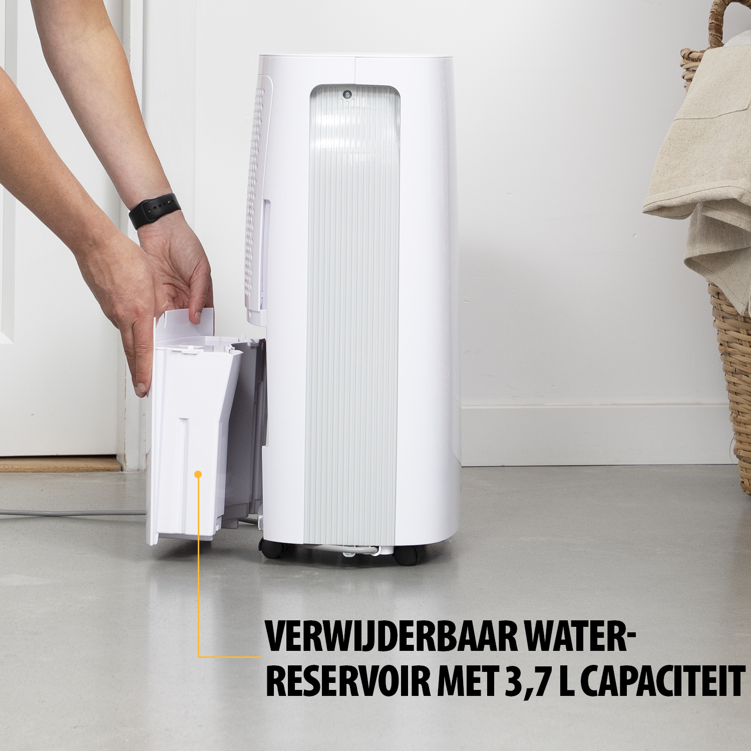 Osoba wyjmuje biały zbiornik na wodę z białego osuszacza. Tekst mówi: WYJMOWANY ZBIORNIK NA WODĘ O POJEMNOŚCI 3,7 L.