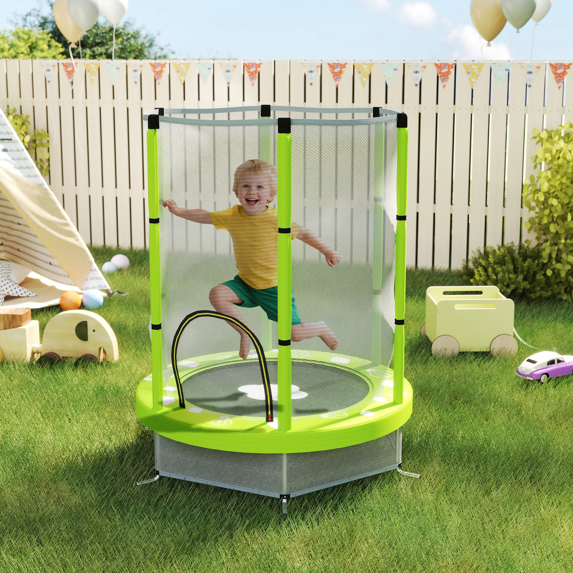 Un bambino salta su un trampolino verde in un cortile. Palloncini e una staccionata bianca sullo sfondo.