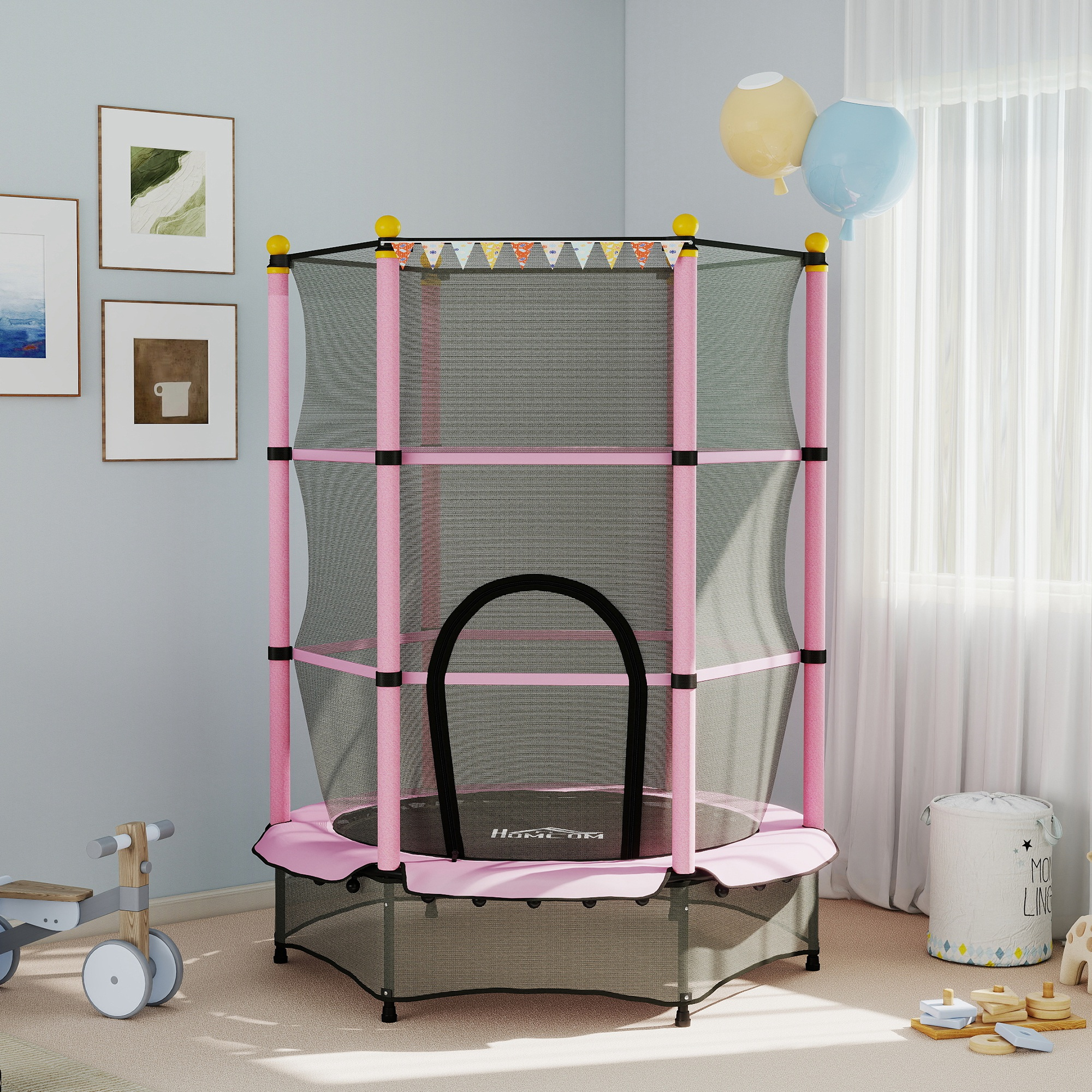 Un trampolino rosa con rete di sicurezza, decorato con piccole bandiere, palloncini e giocattoli per bambini in una stanza.
