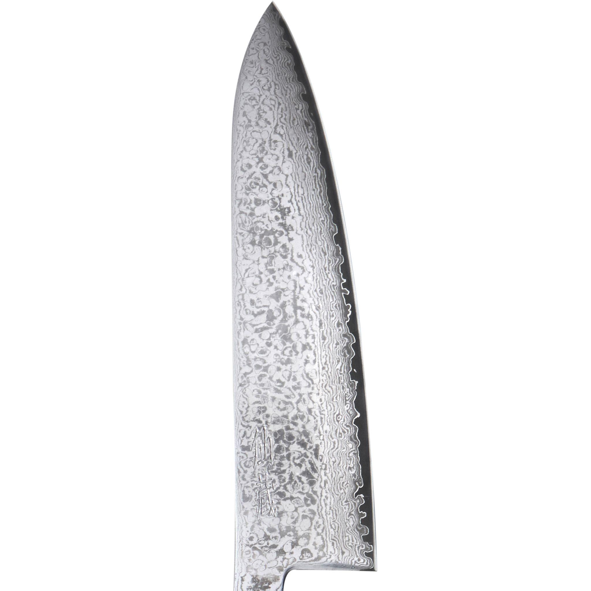 Nahaufnahme einer gemusterten Messerklinge. Sie hat eine scharfe Spitze und eine gezahnte Kante, vor weißem Hintergrund.