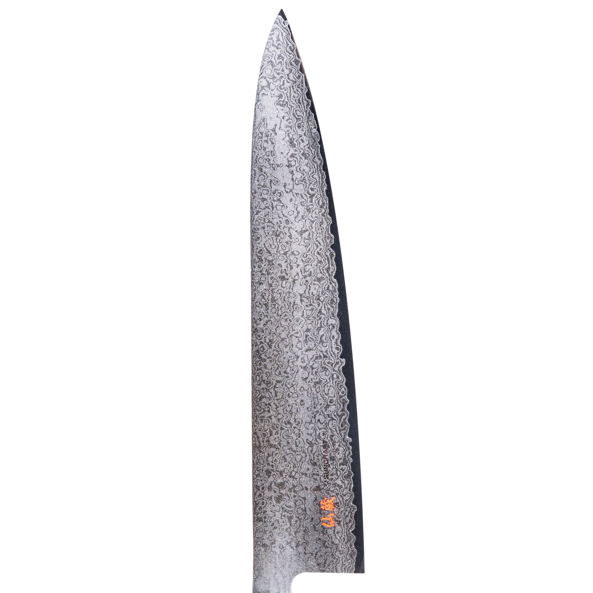 Nahaufnahme einer Messer klinge mit gemustertem Design auf weißem Hintergrund. Die Klinge hat eine scharfe Spitze.