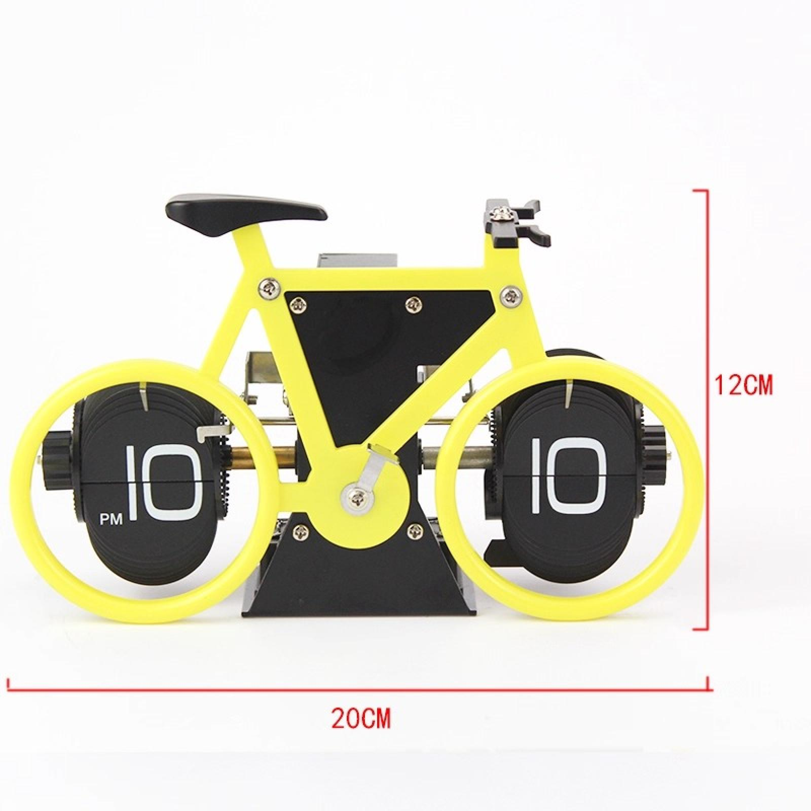 Eine fahrradförmige Uhr, gelber Rahmen, schwarze Räder mit der Zahl 10. Es ist auf einer weißen Oberfläche.