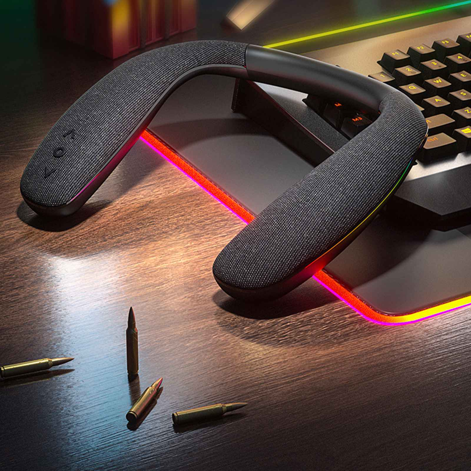 Nackenband-Lautsprecher auf einem Schreibtisch mit Kugeln. Tastatur im Hintergrund. Der Schreibtisch hat einen leuchtenden Rand.