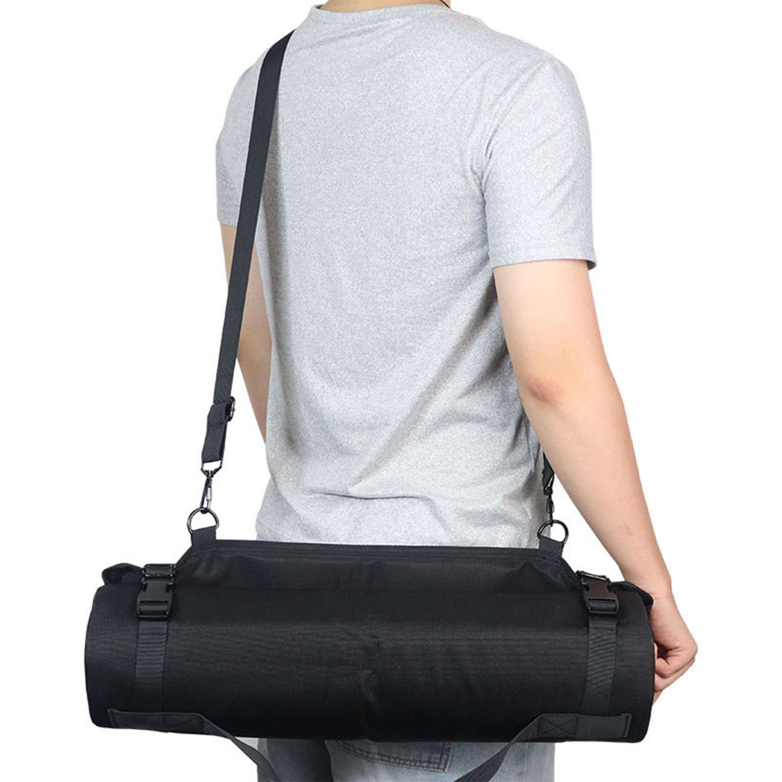 Eine Person von hinten trägt ein graues T-Shirt und eine schwarze zylindrische Tasche mit Schulterriemen.