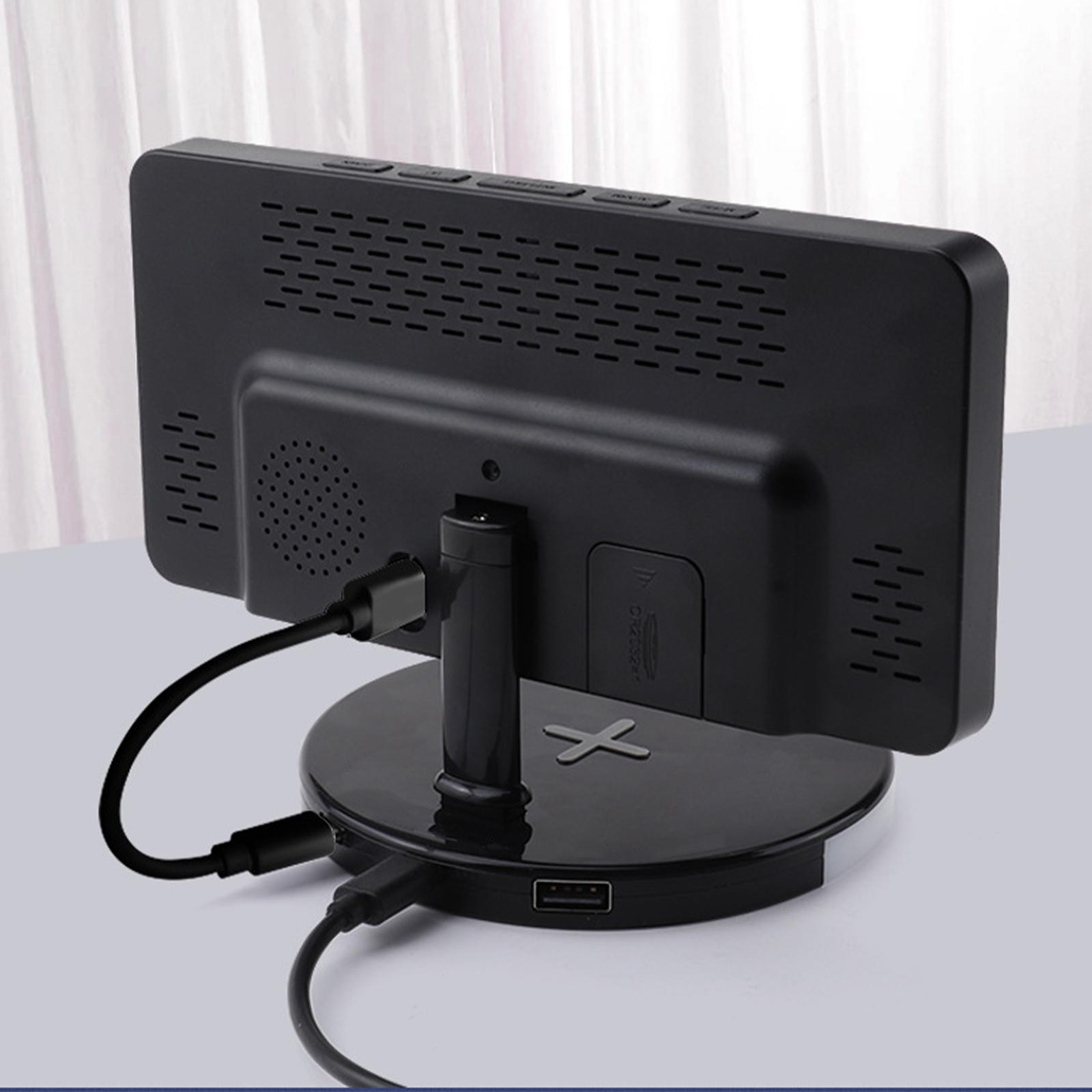 Schwarze Monitorrückseite mit USB-Kabeln, auf einem schwarzen Ständer. Weißer Vorhang im Hintergrund.