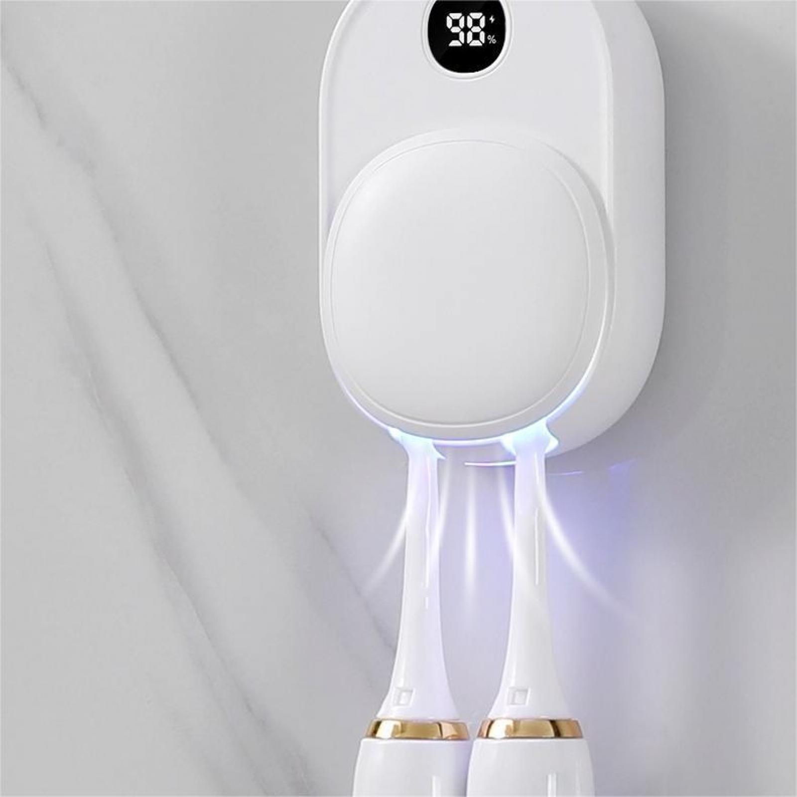 Weißer Zahnbürsten-Sanitizer mit Digitalanzeige, die 98 % anzeigt. Zwei Zahnbürsten hängen darunter. Marmorwand.
