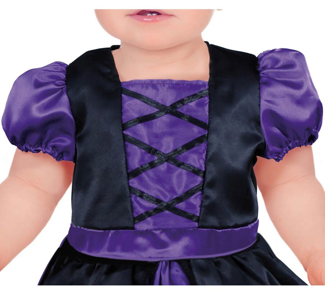 Un bebé con un disfraz de bruja morado y negro. El disfraz tiene un escote cuadrado, mangas abullonadas y un corpiño negro con detalles morados.