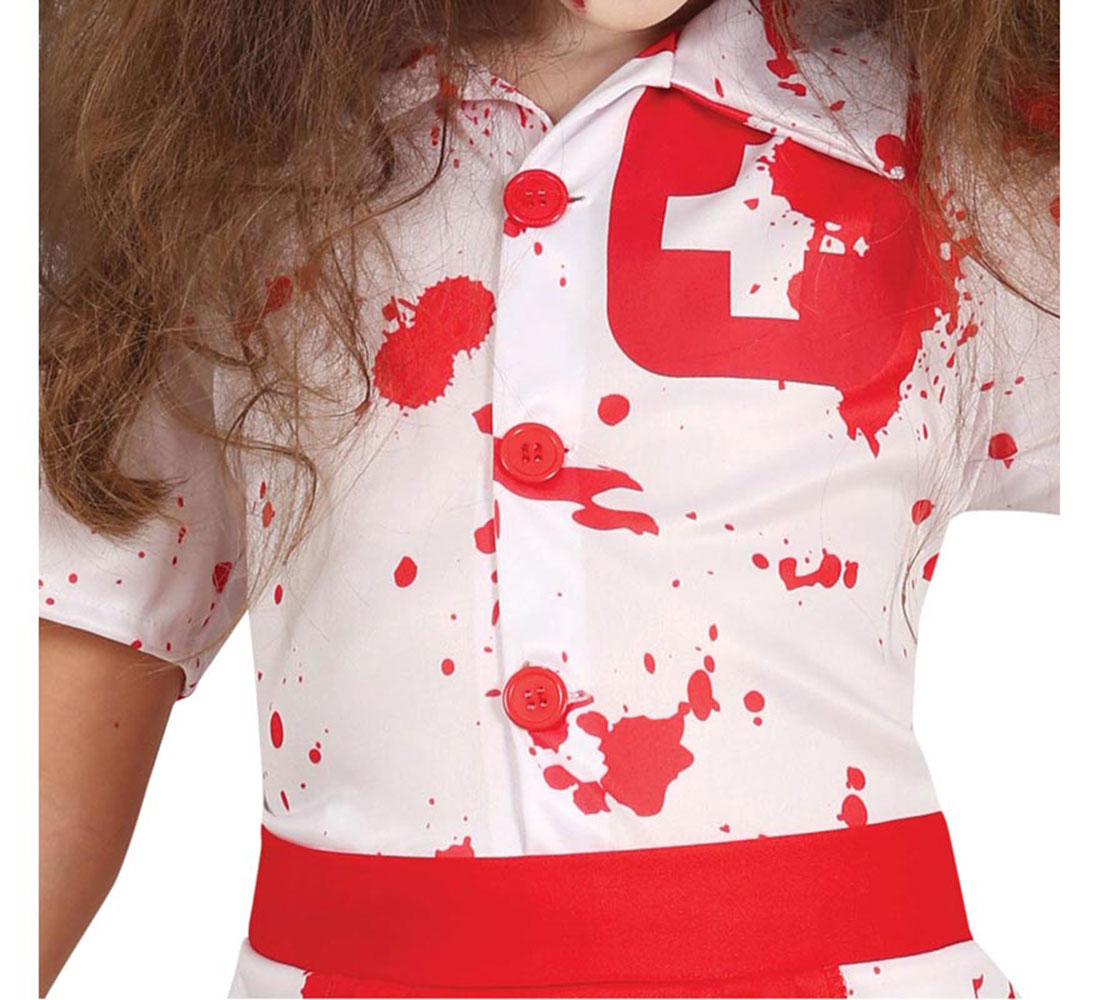 Un niño con un disfraz de enfermera blanco salpicado de pintura roja. El disfraz tiene una cruz roja, botones y un ribete rojo.