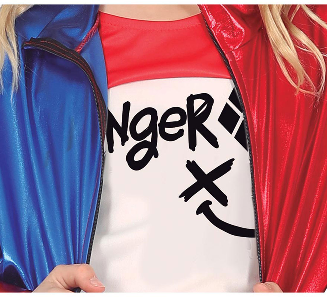 Una persona con un disfraz de Harley Quinn. Una chaqueta roja y azul sobre una camiseta blanca con "Nger" y un símbolo de diamante. Pelo rubio visible.