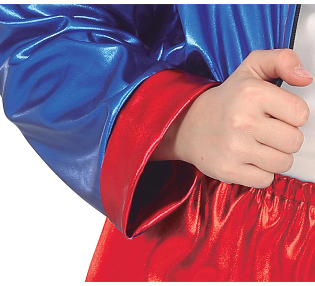Primer plano del brazo de una persona con una chaqueta azul brillante y puños rojos. Se ven pantalones rojos brillantes. Una mano sostiene una cremallera.