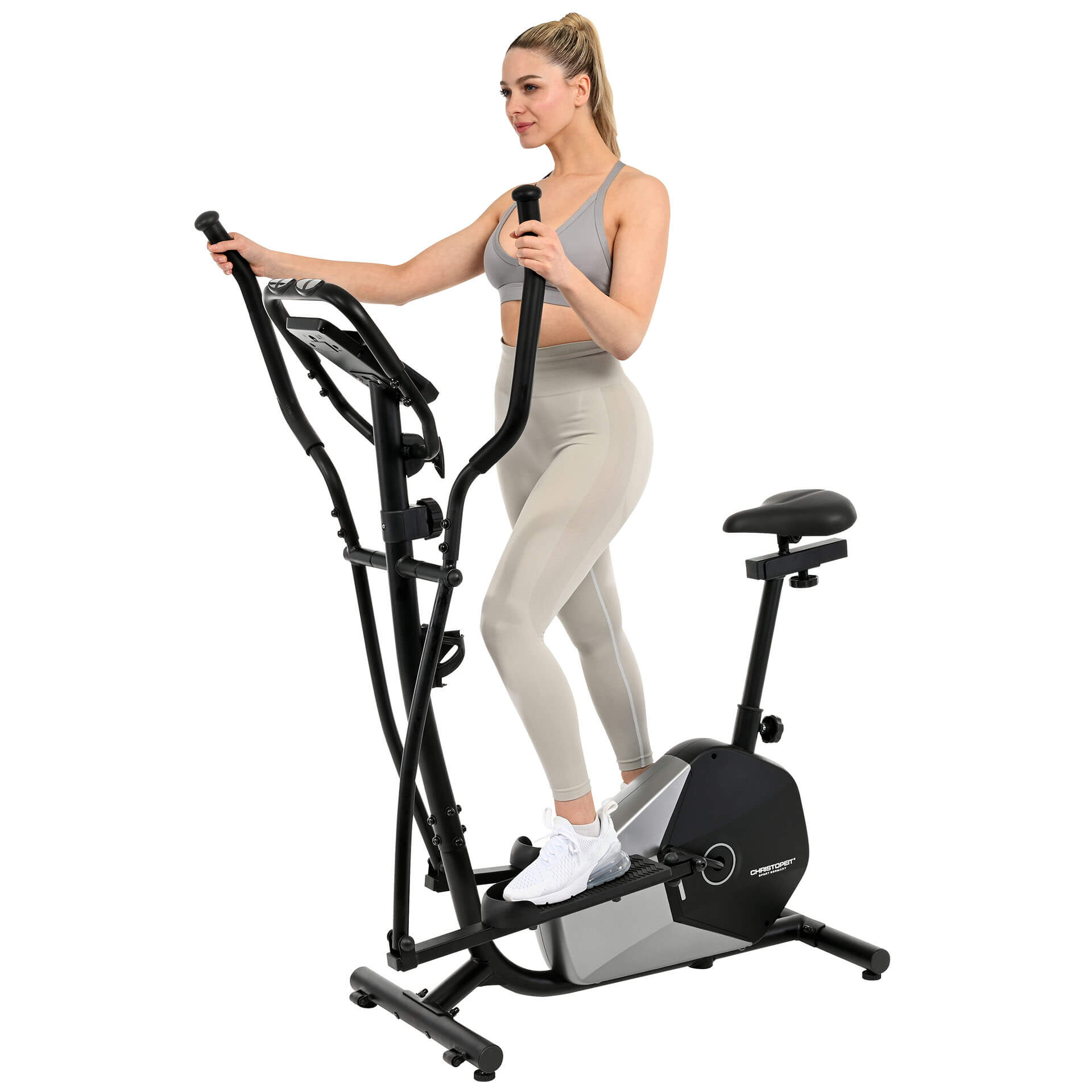 Eine Frau trainiert auf einem Crosstrainer. Sie trägt einen grauen Sport-BH und Leggings sowie weiße Turnschuhe.