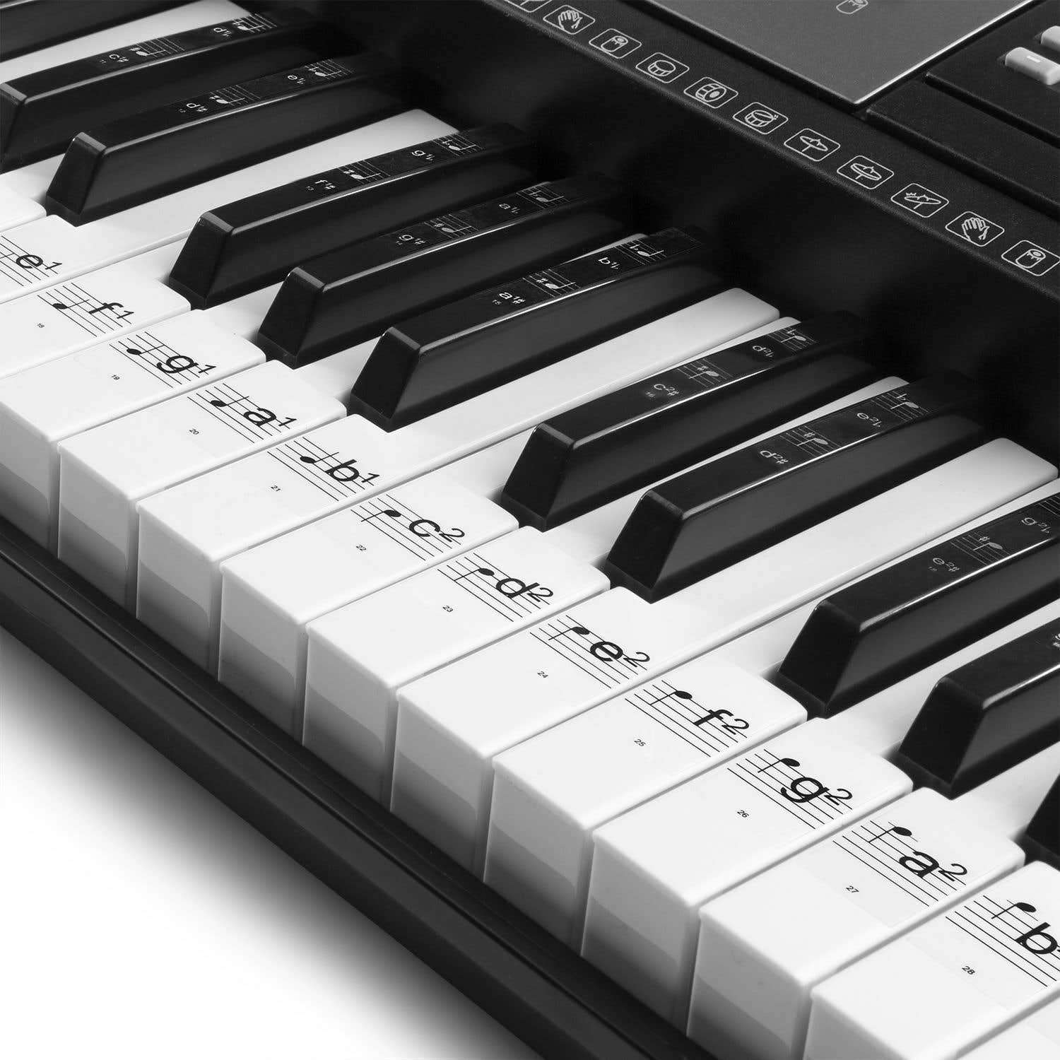 Primer plano de un teclado de piano con teclas blancas y negras. Notas musicales y letras en las teclas blancas.