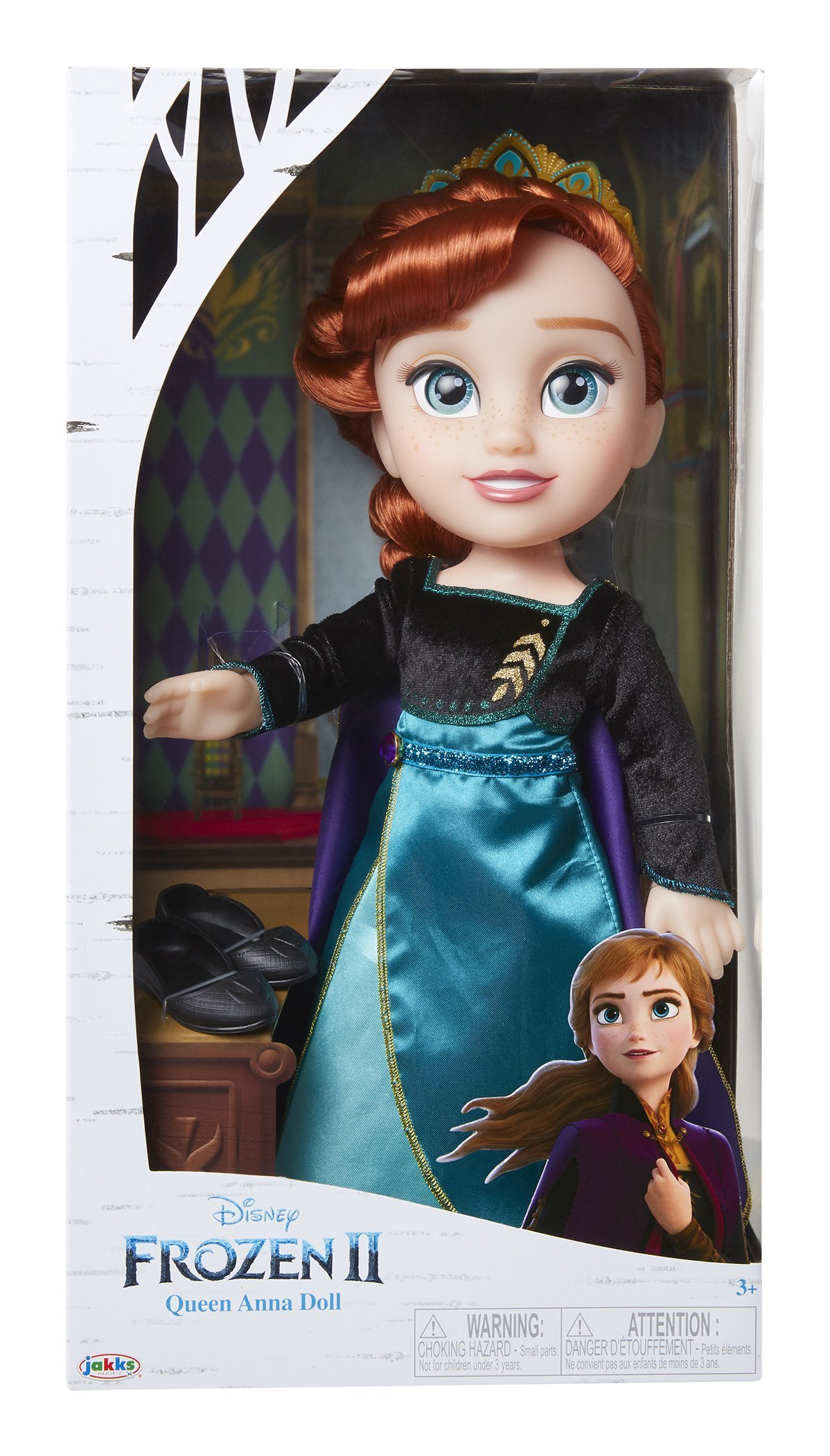 Una muñeca de la Reina Anna de Frozen II en una caja. Anna tiene pelo rojo, un vestido turquesa y una corona. La caja tiene un diseño de abedul.