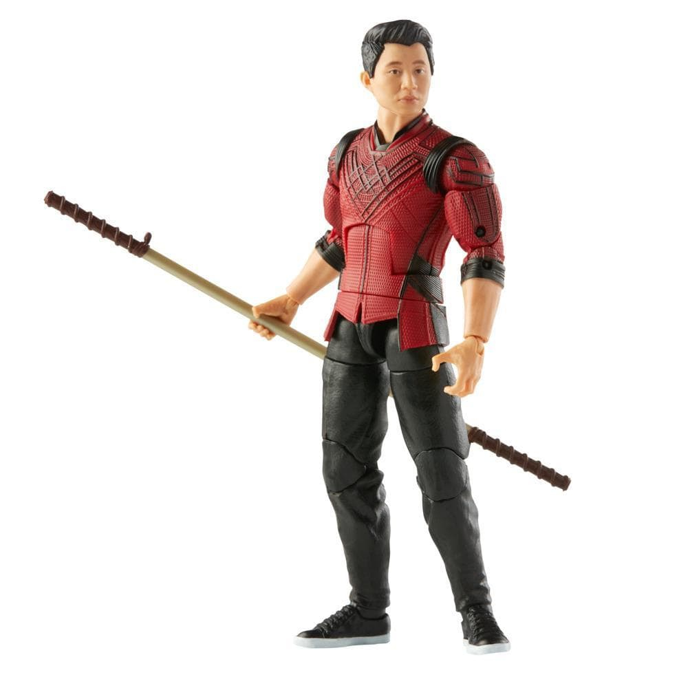Action figure di un uomo in abito rosso e nero che tiene un bastone. La figura è su sfondo bianco.