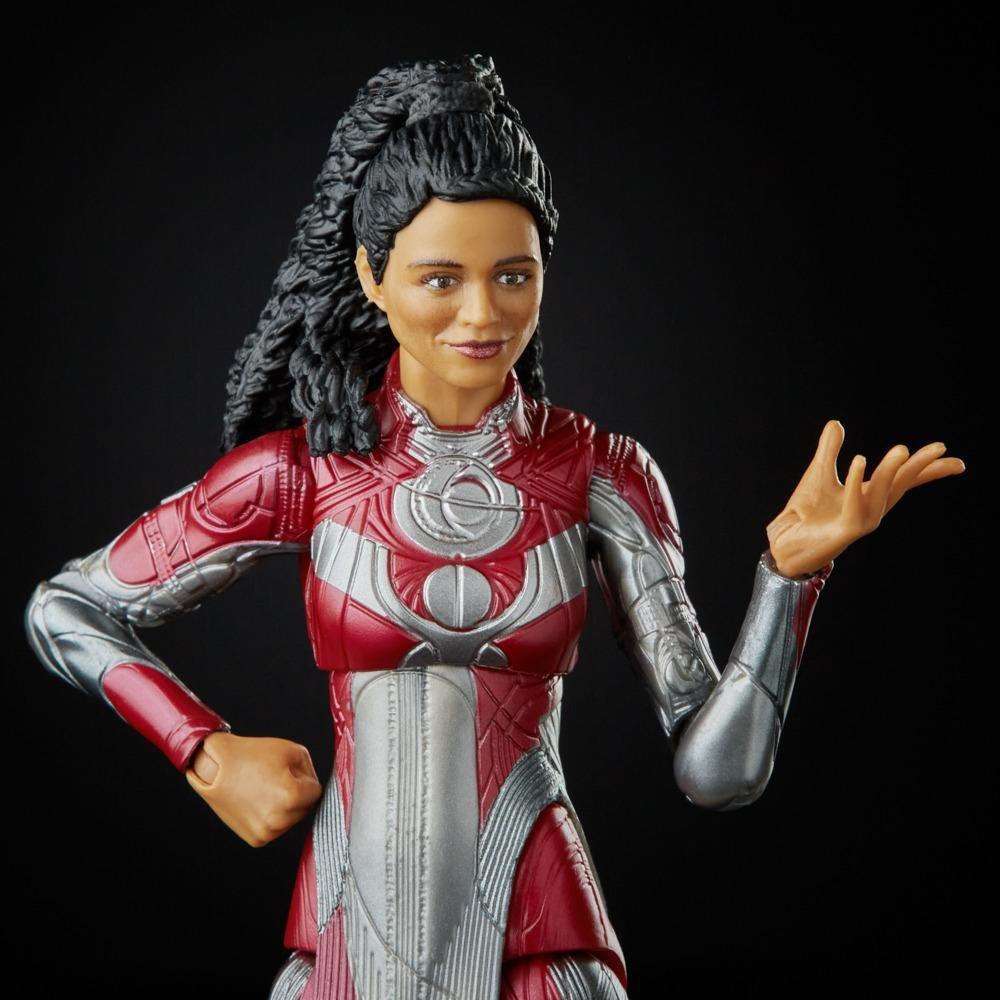 Una action figure femminile in tuta rossa e argento, con capelli neri, che gesticola con la mano destra. Sfondo nero.