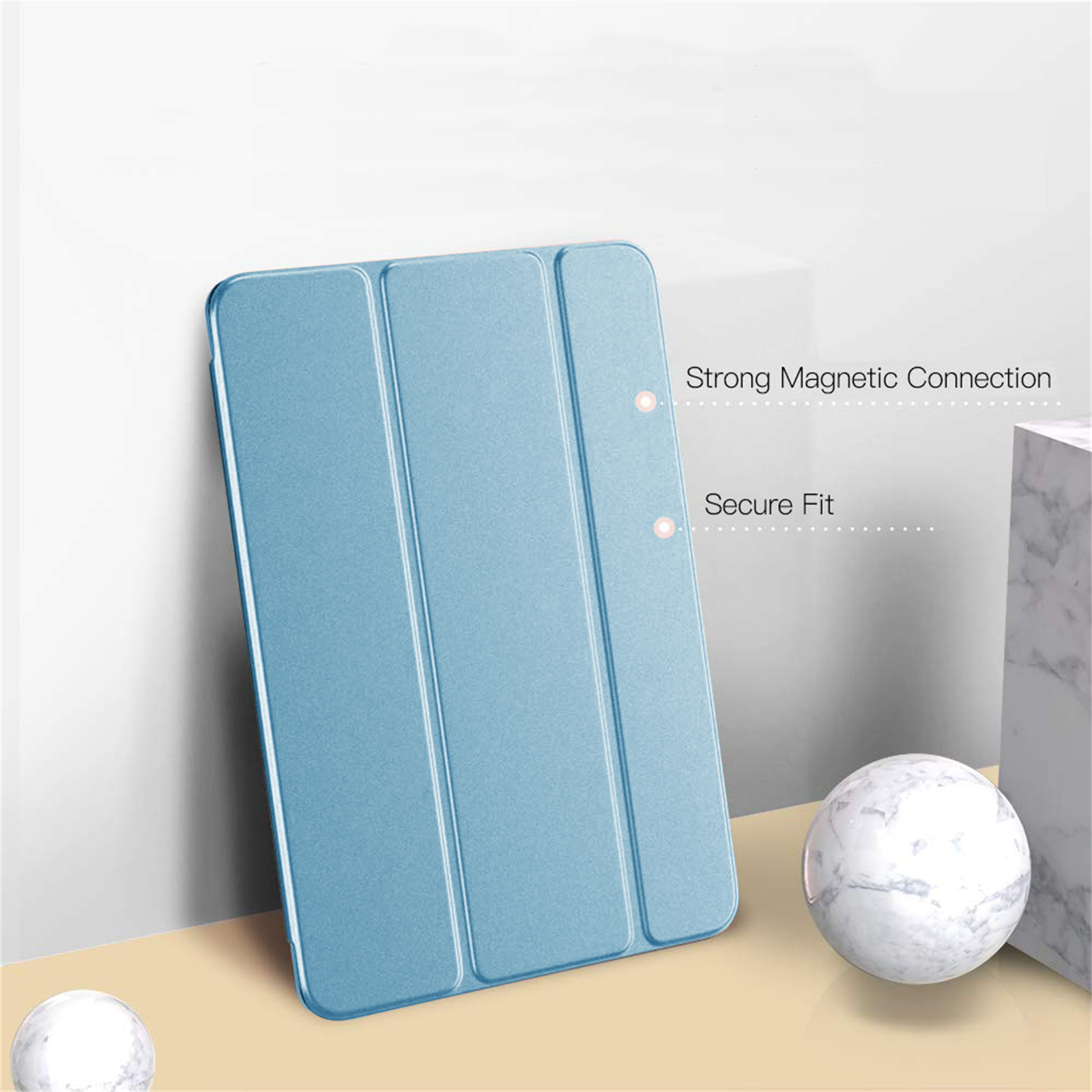 Eine blaue Tablethülle wird mit einer Murmel und einem Marmorblock gezeigt. Der Text lautet 'Starke magnetische Verbindung' und 'Sicherer Sitz'.