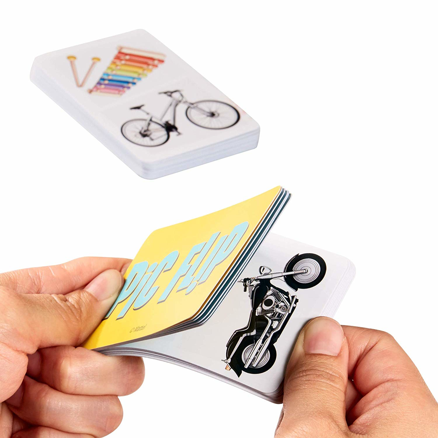 Hände blättern durch Karteikarten mit Bildern von Fahrrad, Xylophon und Motorrad. Karten haben gelbe und weiße Hintergründe.