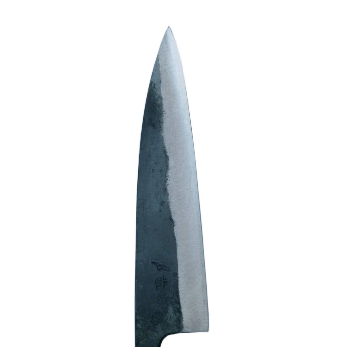 Nahaufnahme eines japanischen Messers. Die Klinge ist dunkelgrau und spitz, vor weißem Hintergrund. Kleine Markierungen sind sichtbar.