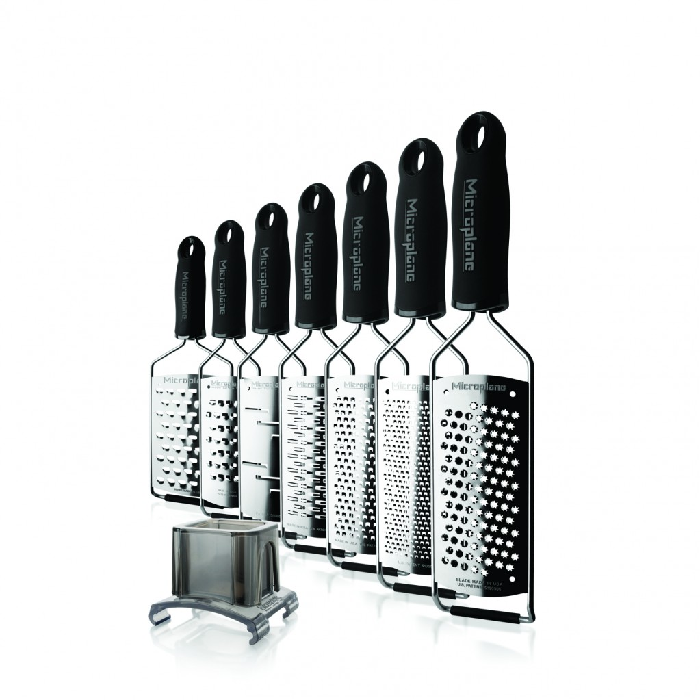 Satz Microplane-Reiben. Schwarze Griffe, Edelstahlklingen. Davor steht ein kleiner Behälter.