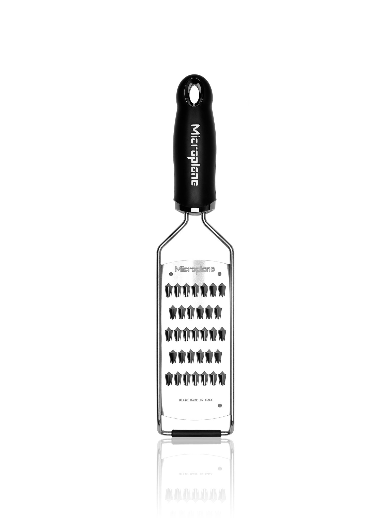 Ein Microplane-Reibeisen mit schwarzem Griff und Edelstahl-Reibefläche. Die Reibe hat kleine Klingen und eine reflektierende Oberfläche.