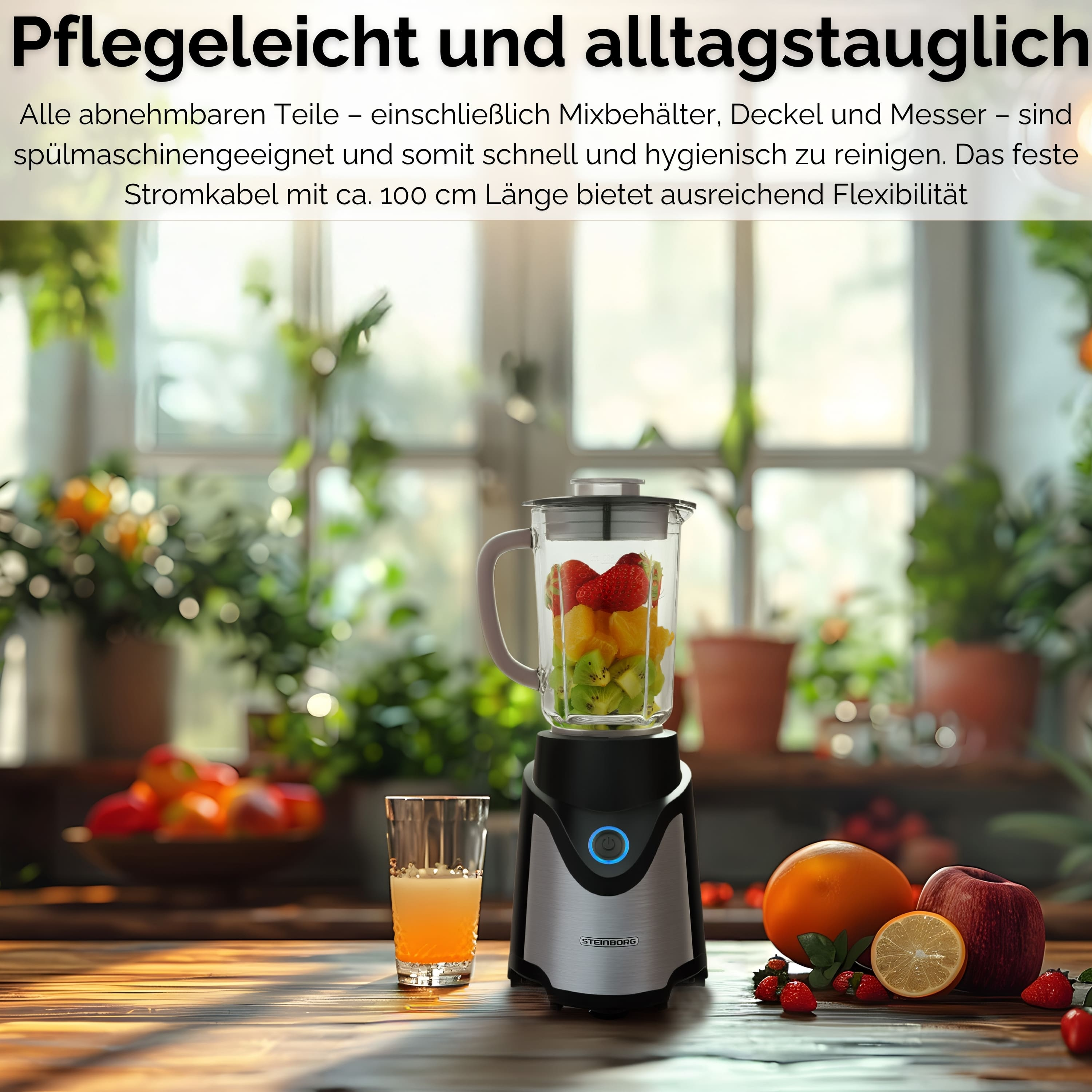 Ein Mixer mit Obst steht auf einem Holztisch mit Obst und einem Glas Saft. Grüne Pflanzen im Hintergrund.