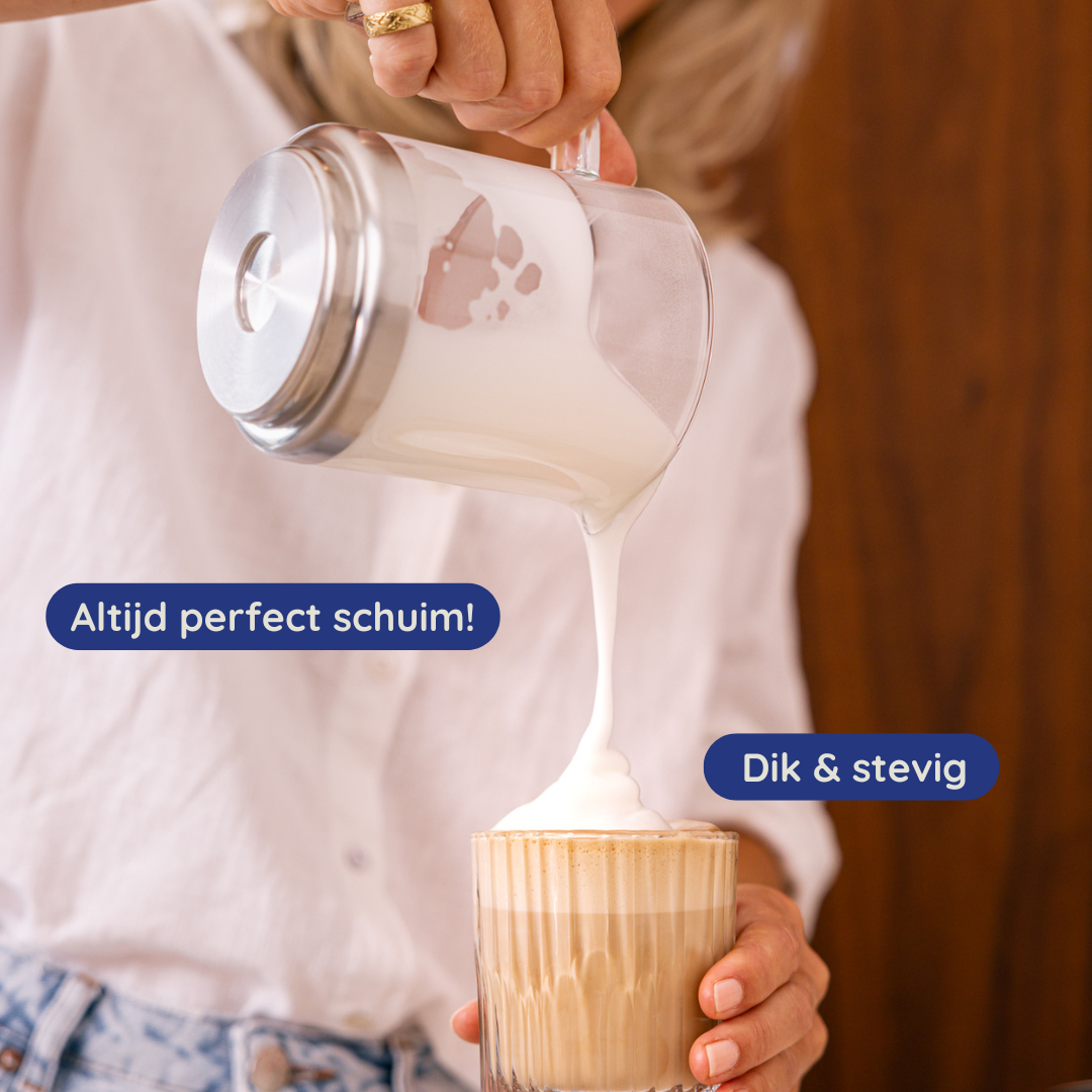Een persoon schenkt opgeschuimde melk in een koffieglas. Het glas is gevuld met koffie. Een tekst zegt 'Altijd perfect schuim!' en 'Dik & stevig'.
