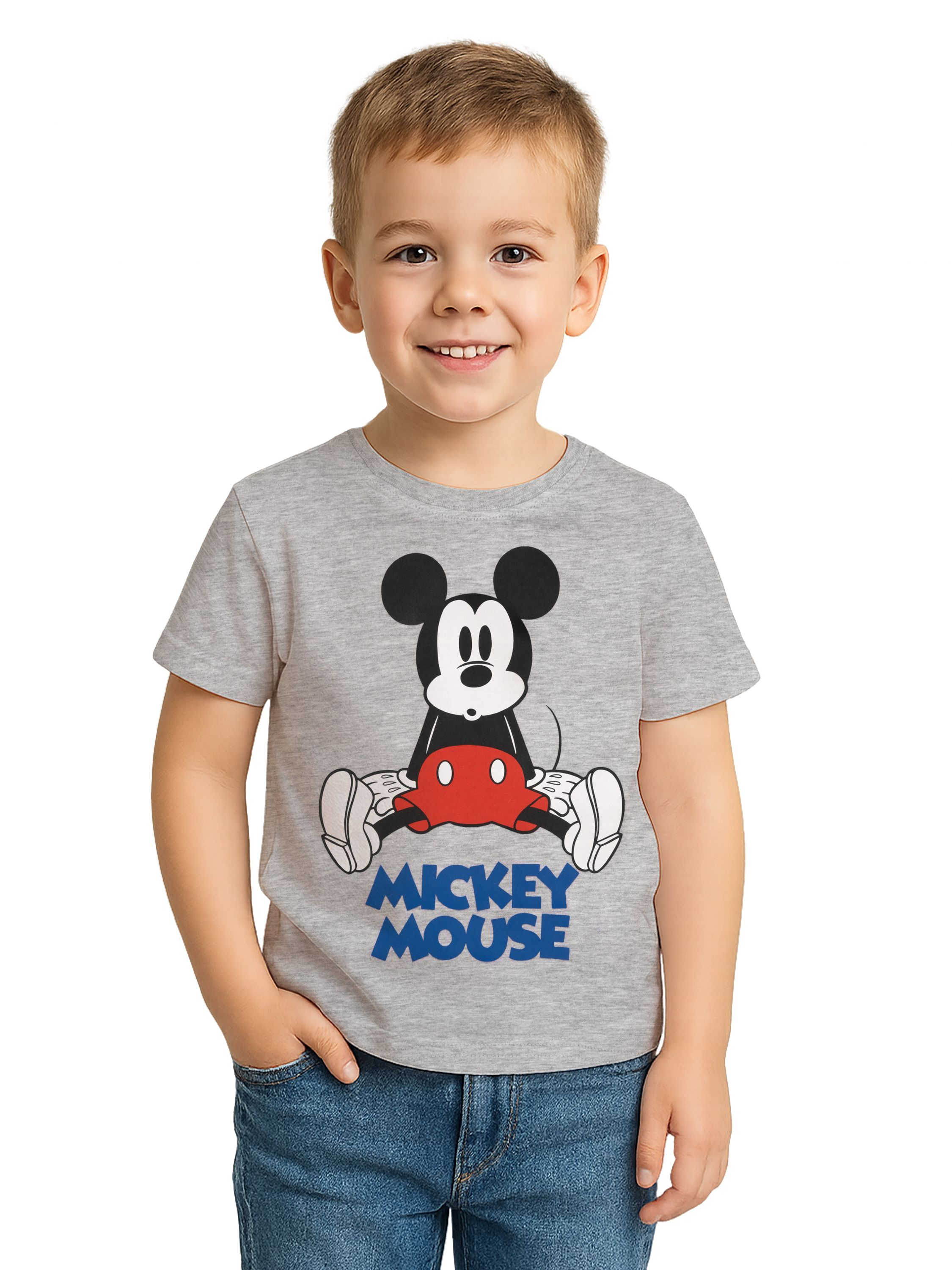 Ein Junge mit grauem Mickey-Mouse-Shirt und Jeans lächelt. Der Hintergrund ist weiß.