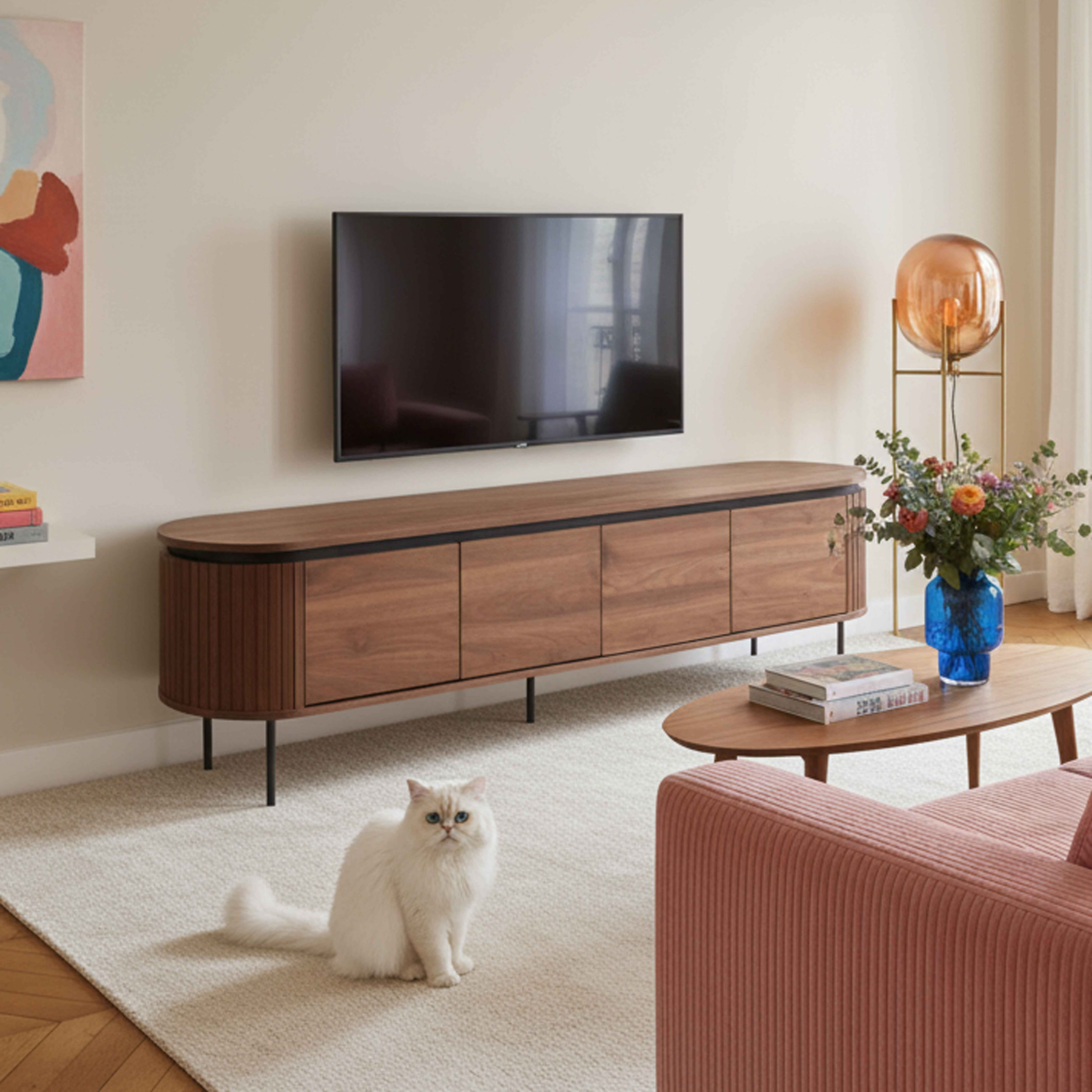 Wohnzimmerszene mit Fernseher, Schrank, Katze, Sofa und Dekor. Weiße Katze sitzt auf dem Teppich.
