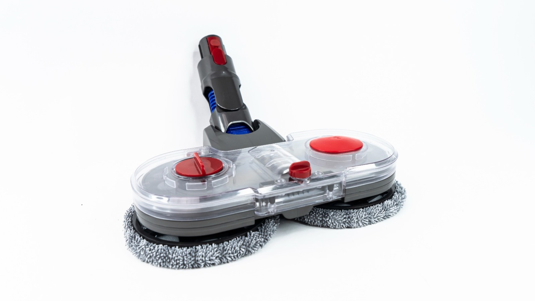 Un cabezal de fregona Dyson sobre un fondo blanco. Tiene partes de plástico grises y transparentes con detalles en rojo. Las almohadillas son grises.