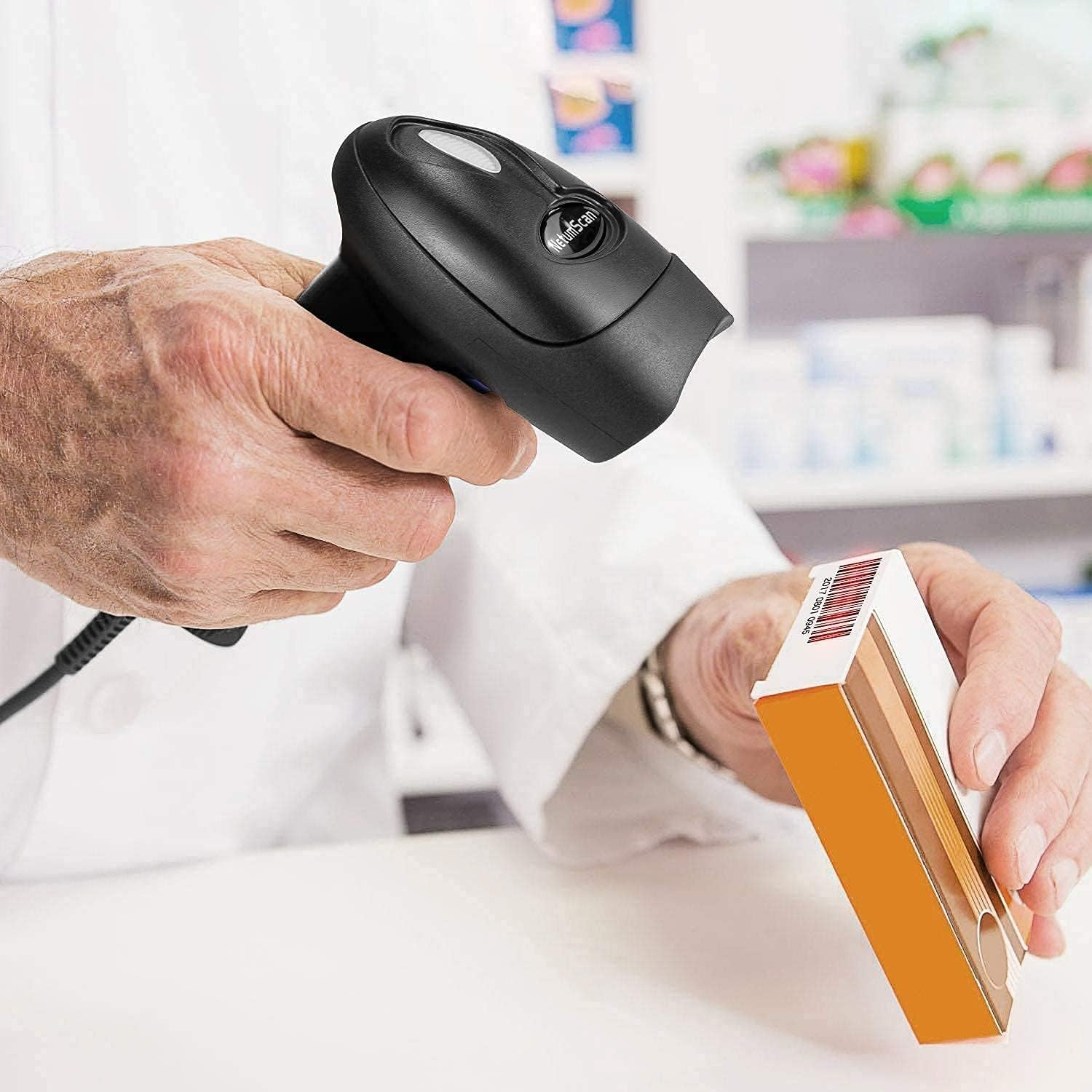 Eine Person im weißen Kittel scannt eine Medikamentenbox mit einem Barcode-Scanner. Die Box ist orange und weiß.