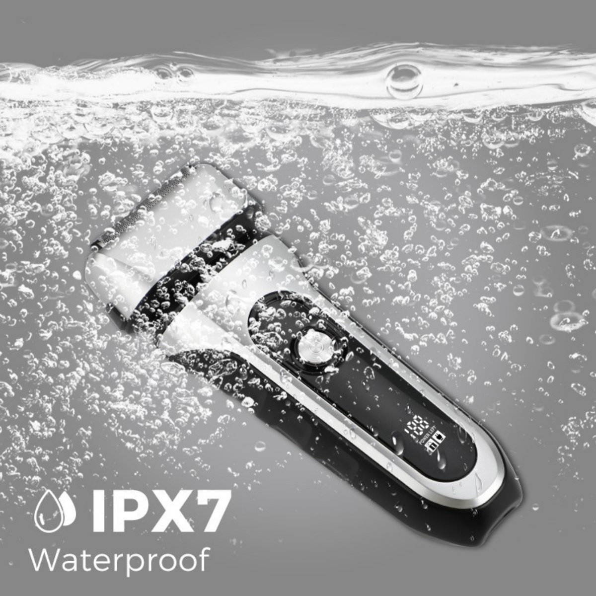 Ein elektrischer Rasierer, der in Wasser mit Blasen eingetaucht ist. Der Rasierer ist schwarz und silber, hat ein digitales Display und ist mit 'IPX7 Waterproof' beschriftet.