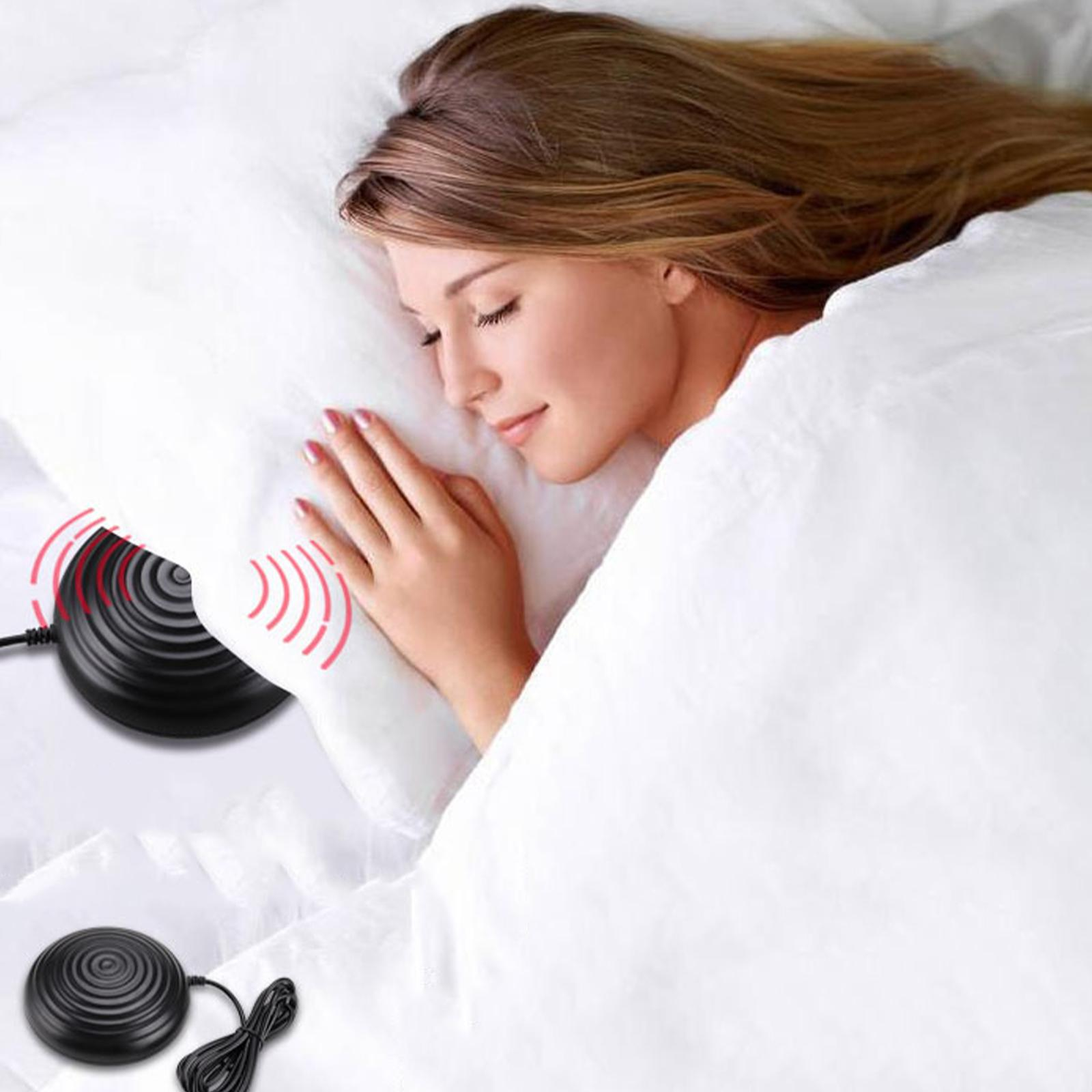 Frau schläft auf einem weißen Bett. Ein schwarzes Gerät mit roten Wellen liegt neben ihrem Kopf.