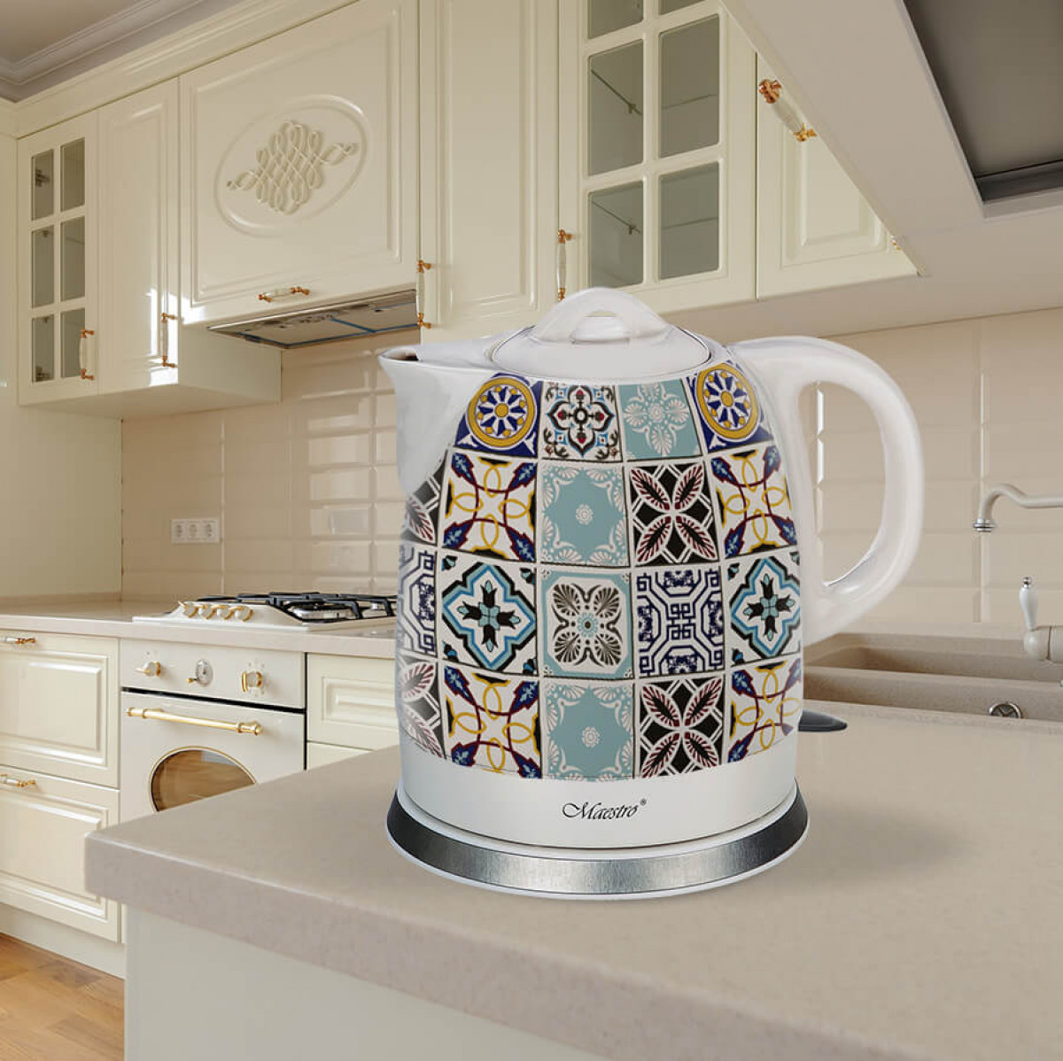 Dekoracyjny czajnik elektryczny z kolorowym wzorem płytek stoi na blacie kuchennym. Kremowe szafki i urządzenia w tle.