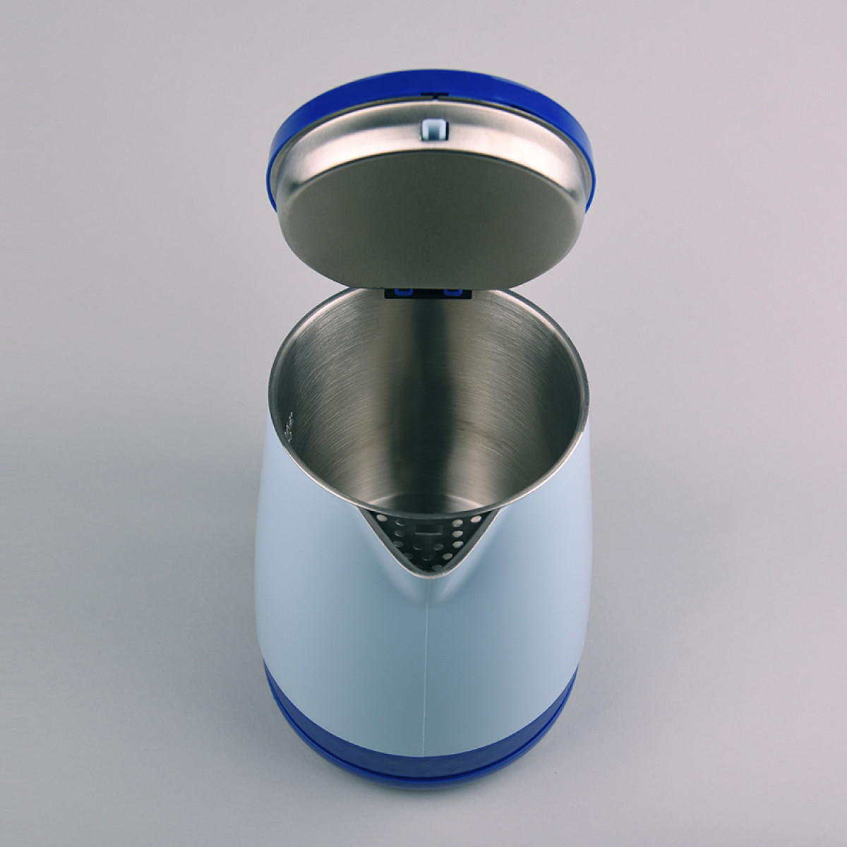 Otwarty czajnik elektryczny. Jest biało-niebieski ze srebrnym wnętrzem. Pokrywa jest uniesiona. Tło jest szare.