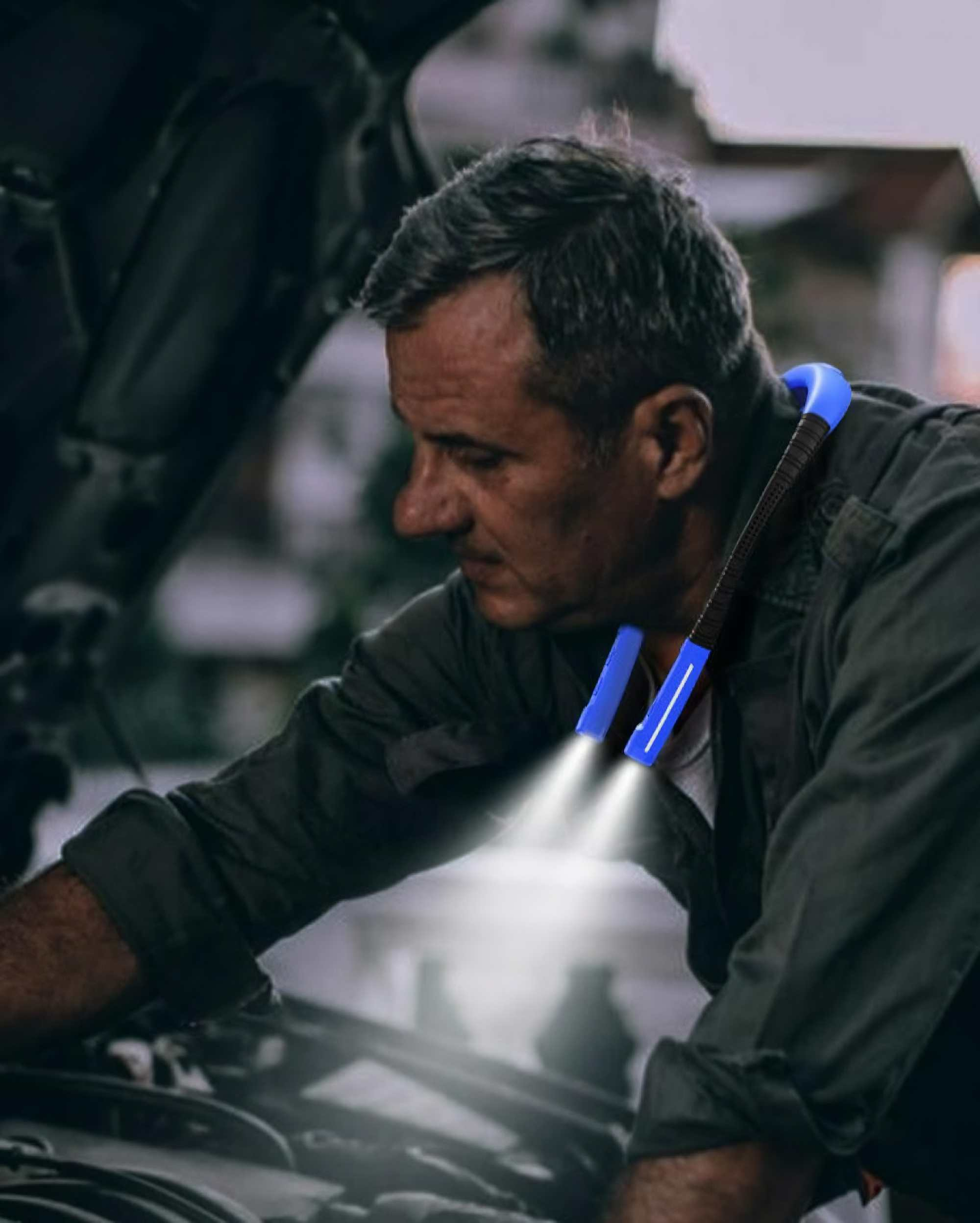 Mann arbeitet an einem Automotor und trägt eine blaue Nackenleuchte. Das Licht scheint auf den Motor.