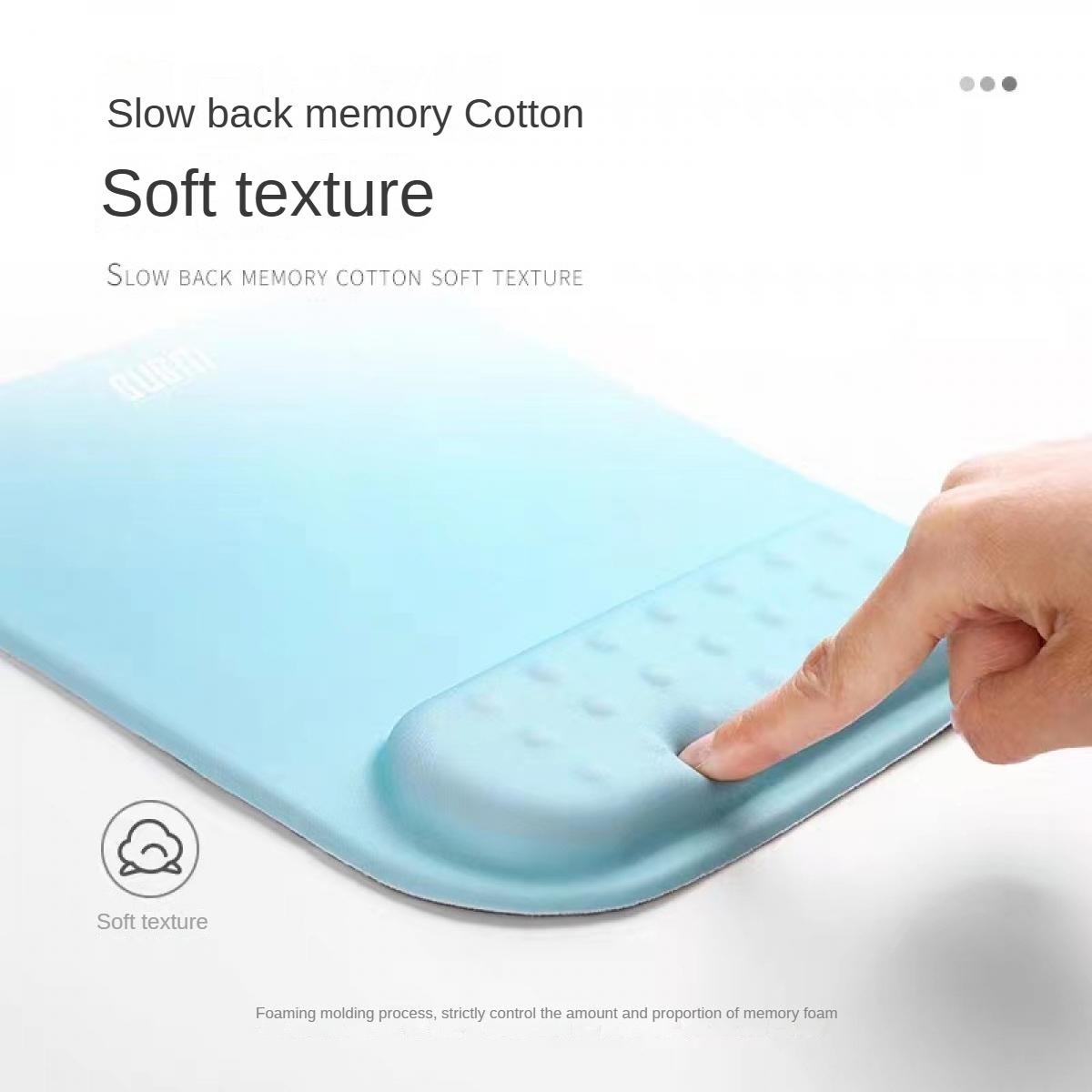 Eine Hand drückt einen Finger in eine hellblaue Memory-Schaum-Handgelenkstütze. Das Bild zeigt eine Nahaufnahme der weichen Textur.