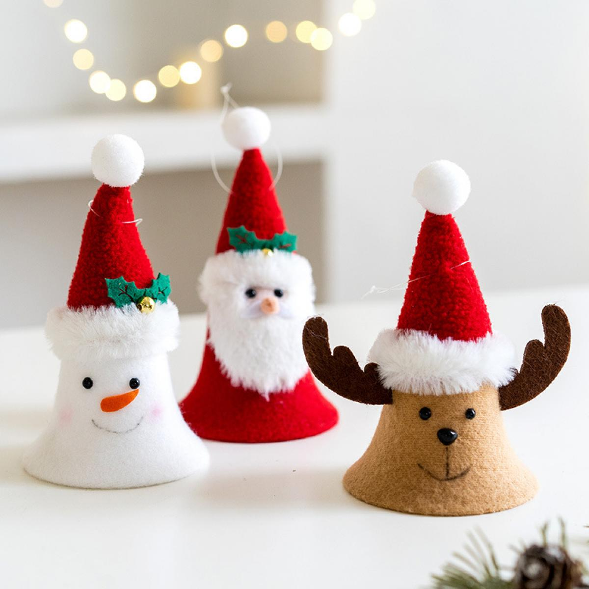 Drei Weihnachtsschmuckstücke: Schneemann, Weihnachtsmann und Rentier. Jeder trägt einen roten Hut mit weißem Rand. Sie stehen auf einer weißen Oberfläche.