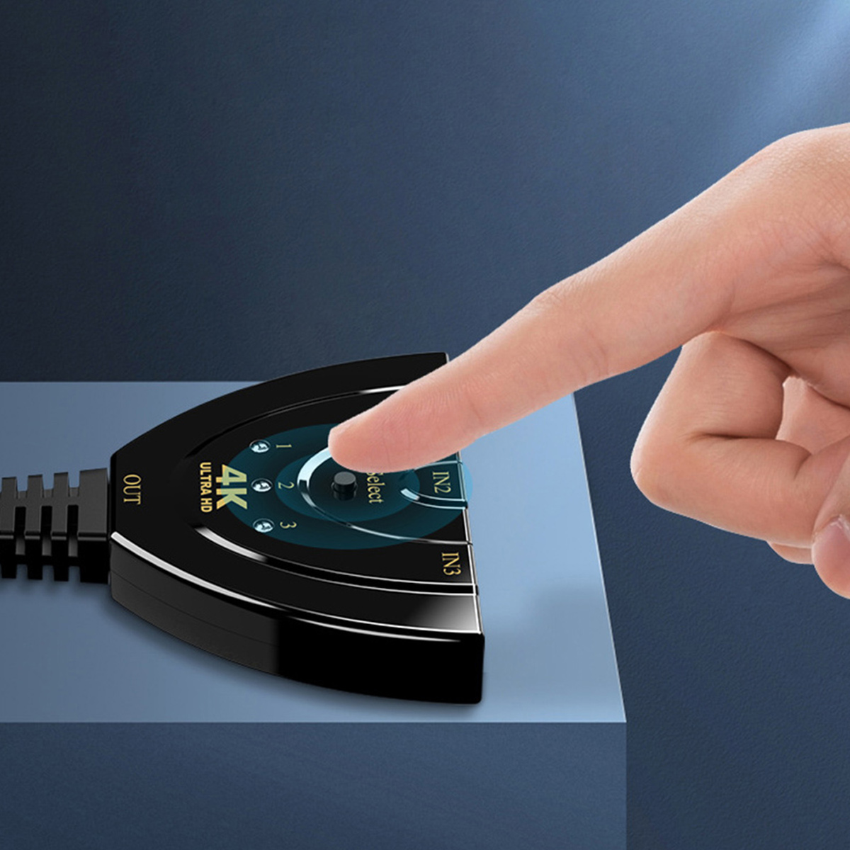 Eine Hand zeigt auf einen schwarzen 4K Ultra HD-Schalter. Der Schalter hat Eingangs- und Ausgangsanschlüsse. Der Hintergrund ist dunkelblau.