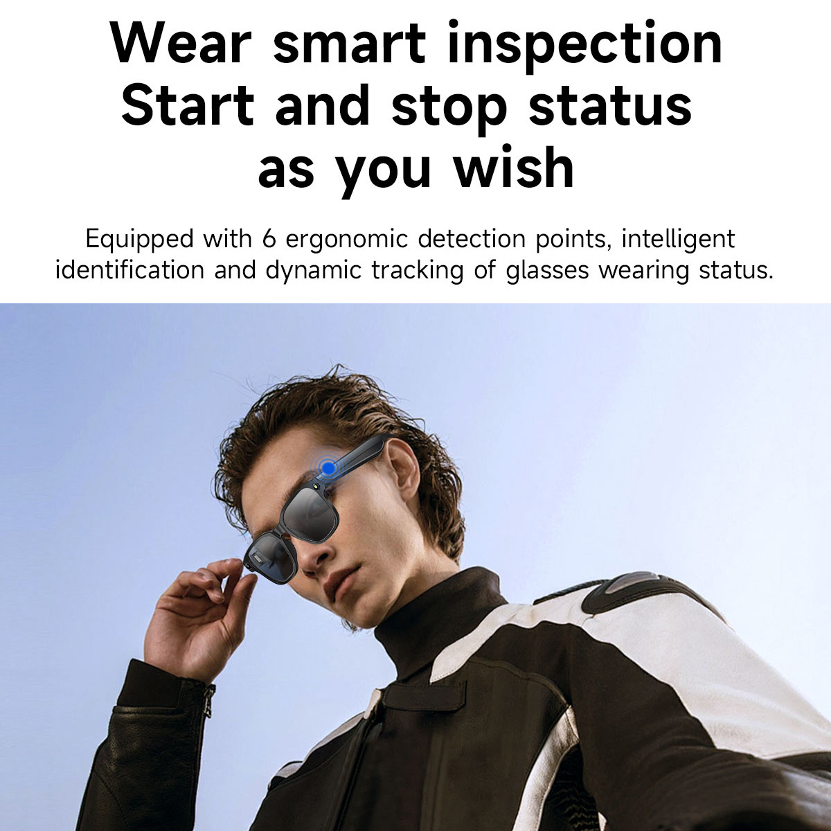 Mężczyzna w inteligentnych okularach, okulary mają niebieskie światło. Ma na sobie czarno-białą kurtkę, na tle błękitnego nieba.