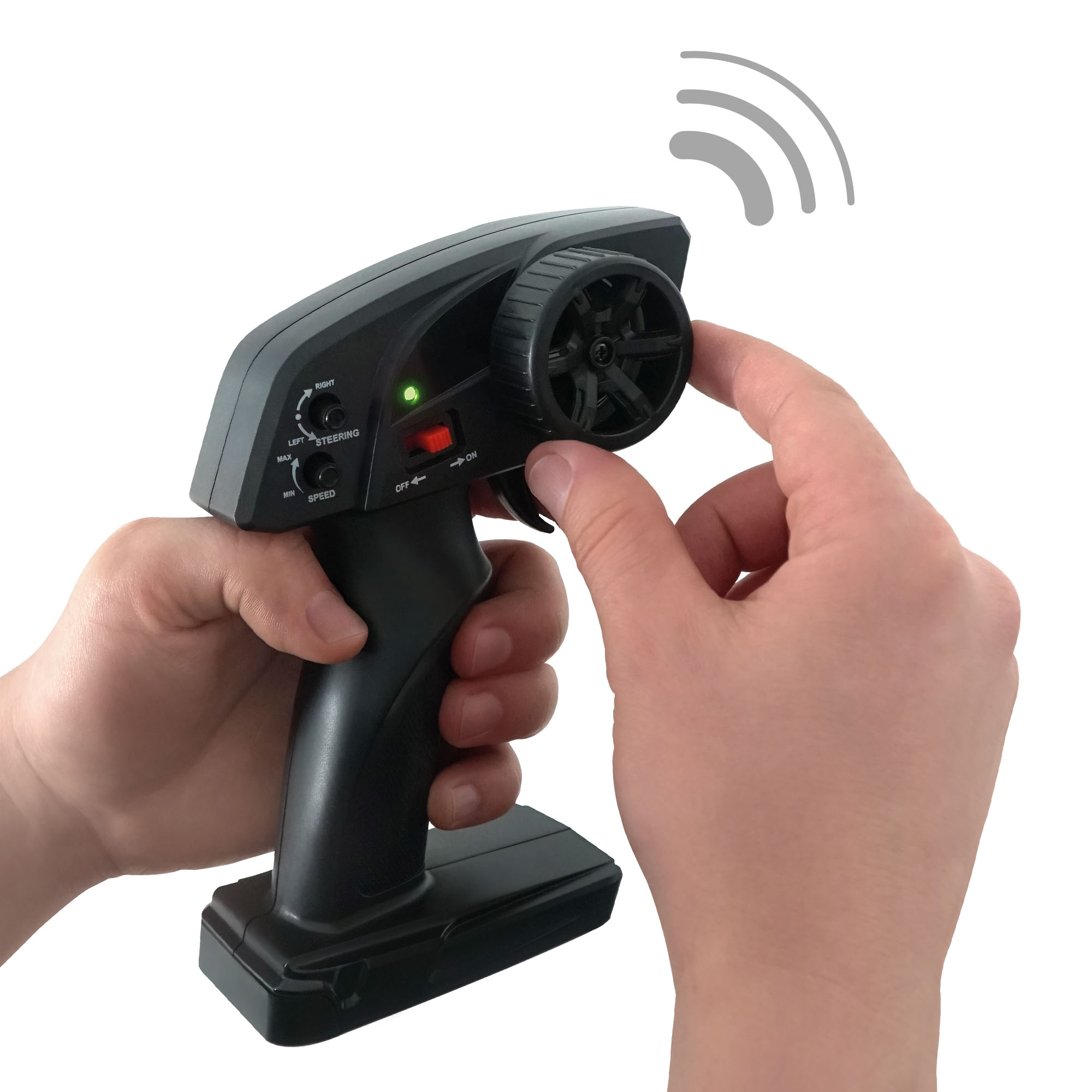Dłonie trzymają czarny kontroler RC. Palce regulują koło. Zielone światło jest włączone. Ikona sygnału bezprzewodowego u góry.
