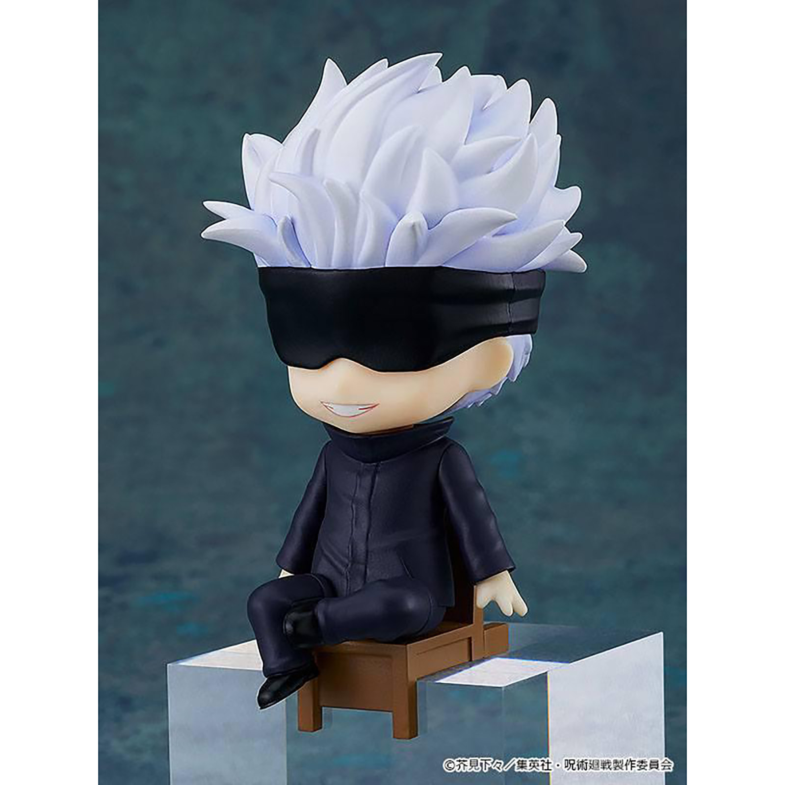 Eine Chibi-Figur mit weißen Haaren, schwarzer Augenbinde und dunklem Outfit, die auf einem winzigen Stuhl sitzt.
