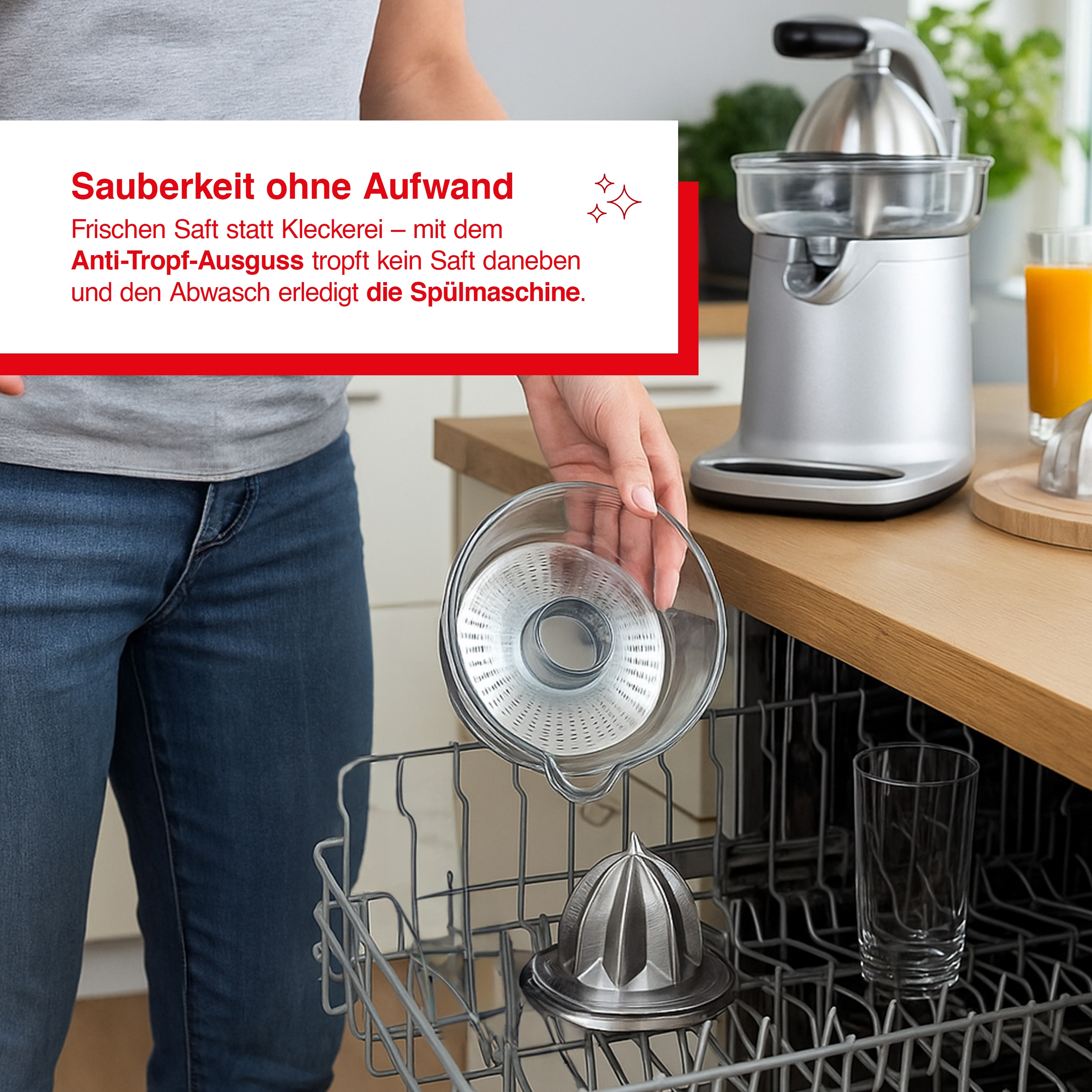 Eine Person legt ein Entsafterteil in eine Spülmaschine. Ein Entsafter und ein Glas stehen auf der Theke.