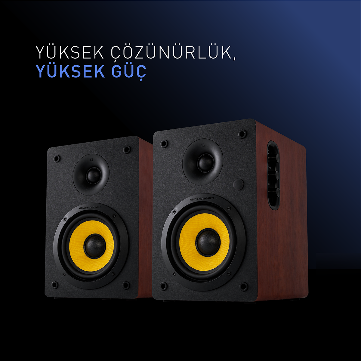 Sarı merkezli iki siyah ve kahverengi hoparlör. Üstte 'Yüksek Çözünürlük, Yüksek Güç' metni. Koyu mavi arka plan.