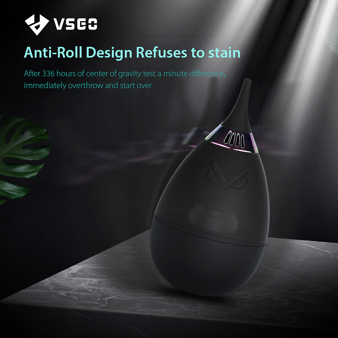Ein schwarzes, eiförmiges Gerät mit einem Eulenlogo und einer leuchtenden Oberseite befindet sich auf einer grauen Oberfläche. Text lautet: 'Anti-Roll Design Refuses to stain'.