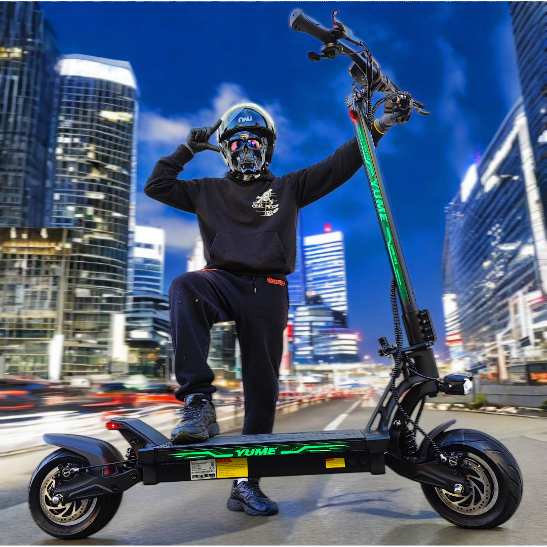 Osoba w kasku i masce czaszki pozuje na czarnej hulajnodze elektrycznej. Wieżowce w tle pod błękitnym niebem.